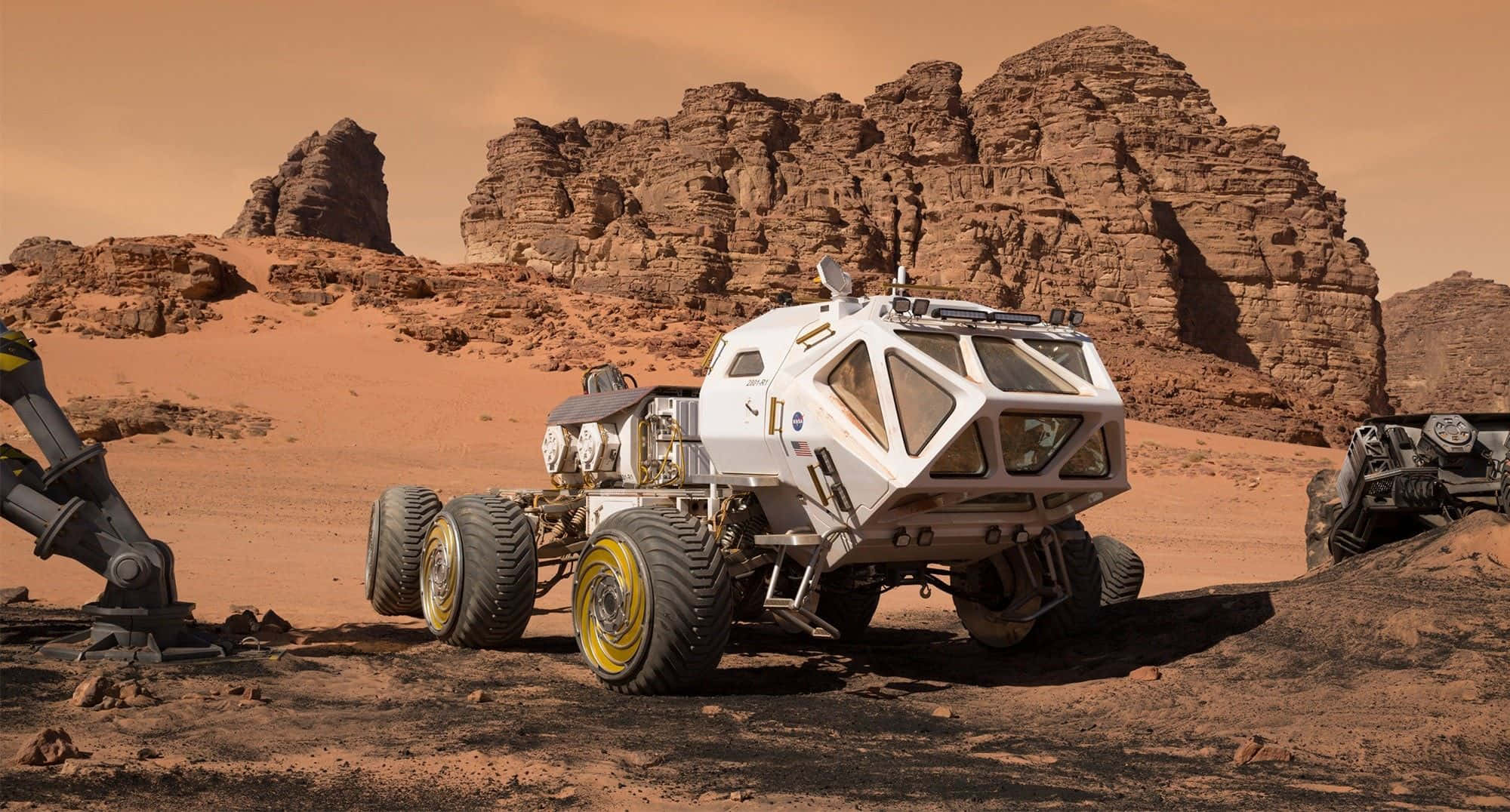 The Martian 桌布 壁紙 — 一輛帶有黃色車輪的未來感白色探測車，在塵土飛揚的橙色天空下探索崎嶇的紅色火星景觀。