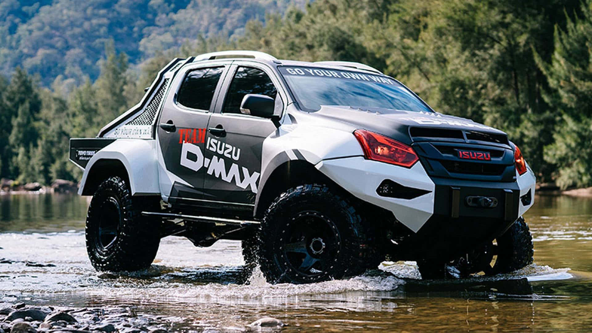 Isuzu 桌布 壁紙 — 一輛帶有黑色裝飾的白色Isuzu D-Max皮卡車在森林覆蓋的山丘環繞的淺河水中涉水而行。