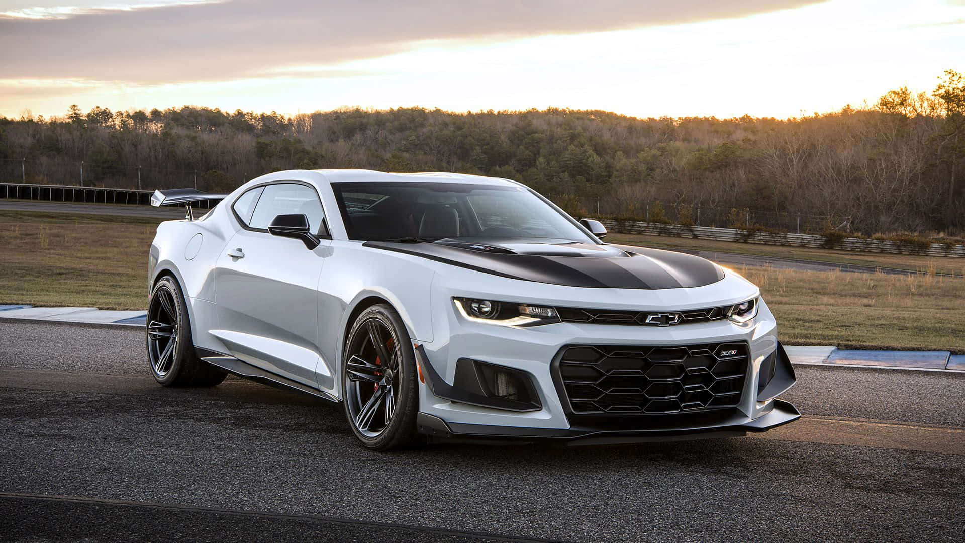 Chevrolet 桌布 壁紙 — 一輛帶有黑色賽車條紋的時尚白色雪佛蘭Camaro ZL1，在黃金時段停放在賽道上。