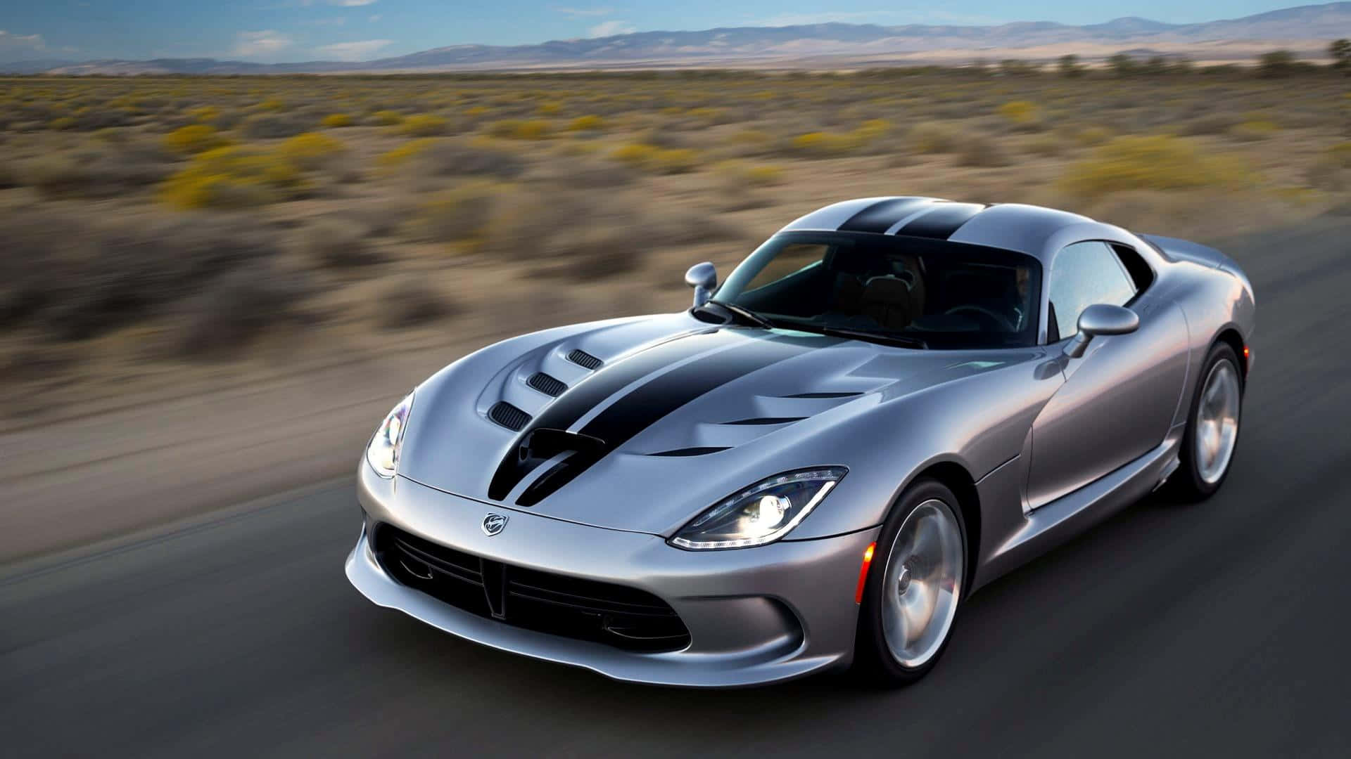 Dodge 桌布 壁紙 — 一輛帶有黑色賽車條紋的銀色道奇Viper在沙漠公路上疾馳，周圍環境模糊。