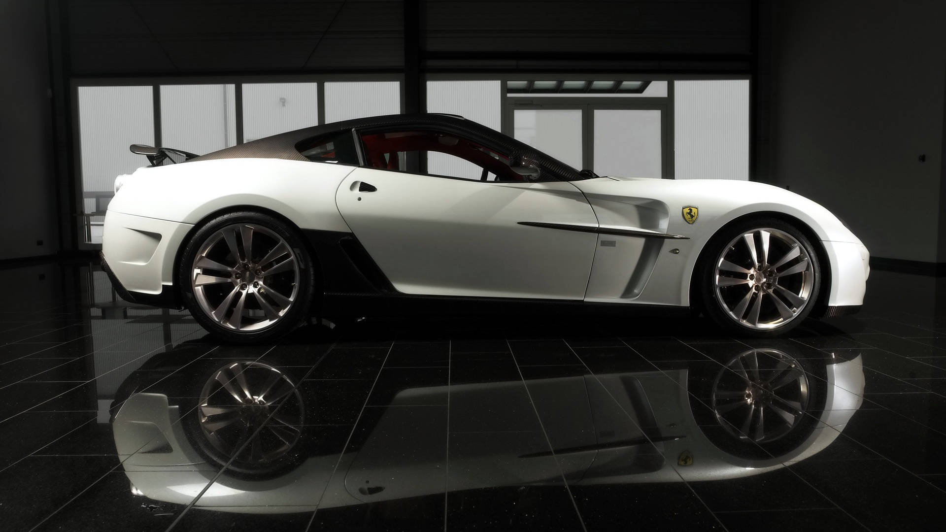white ferrari 桌布 壁紙 — 一輛帶有黑色點綴的時尚白色法拉利跑車在現代展廳中展示，光滑的黑色瓷磚地板反射出其拋光的外形。