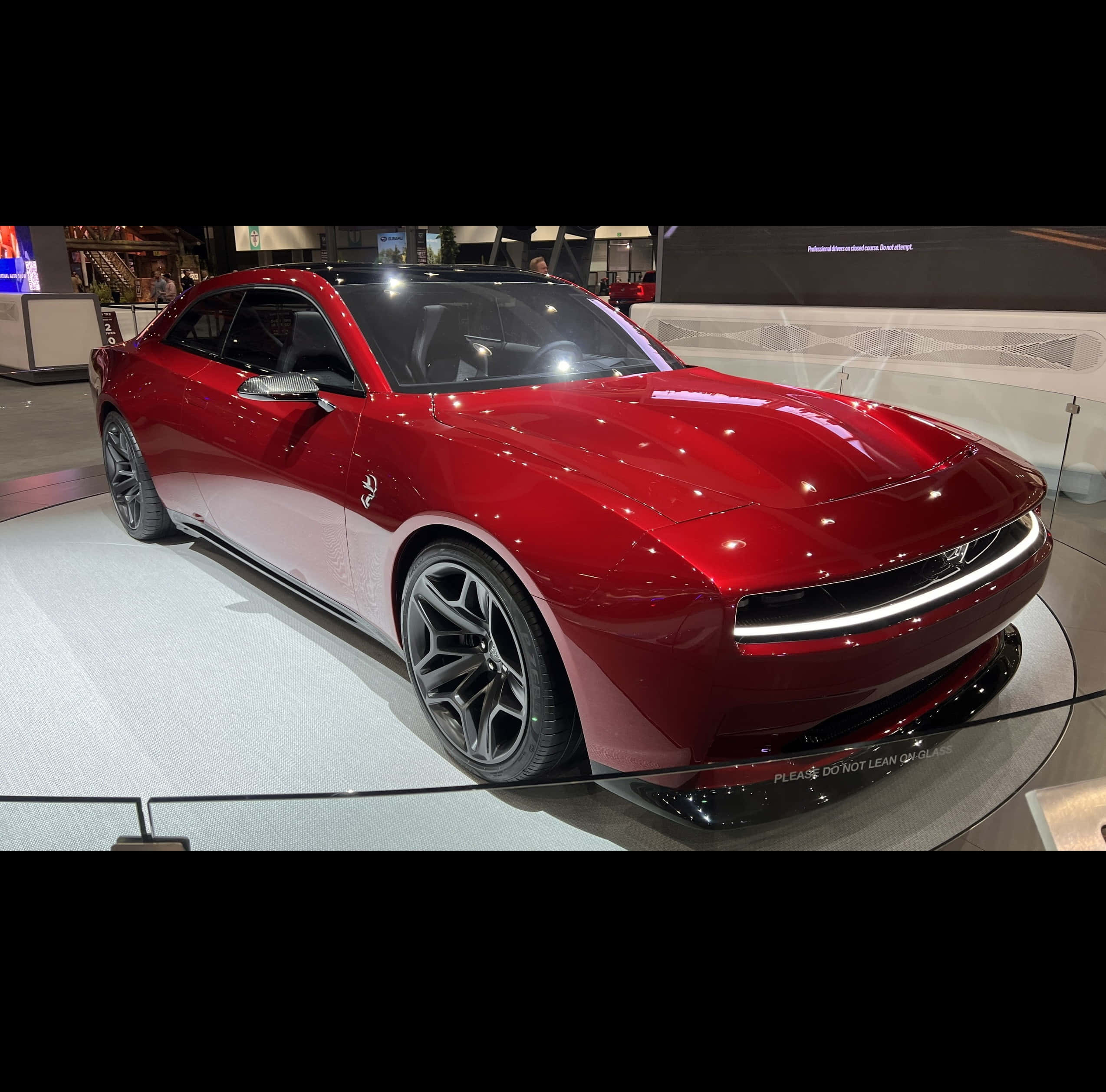 Dodge 桌布 壁紙 — 一輛帶黑色裝飾的亮紅色跑車在車展的圓形展台上閃閃發光。