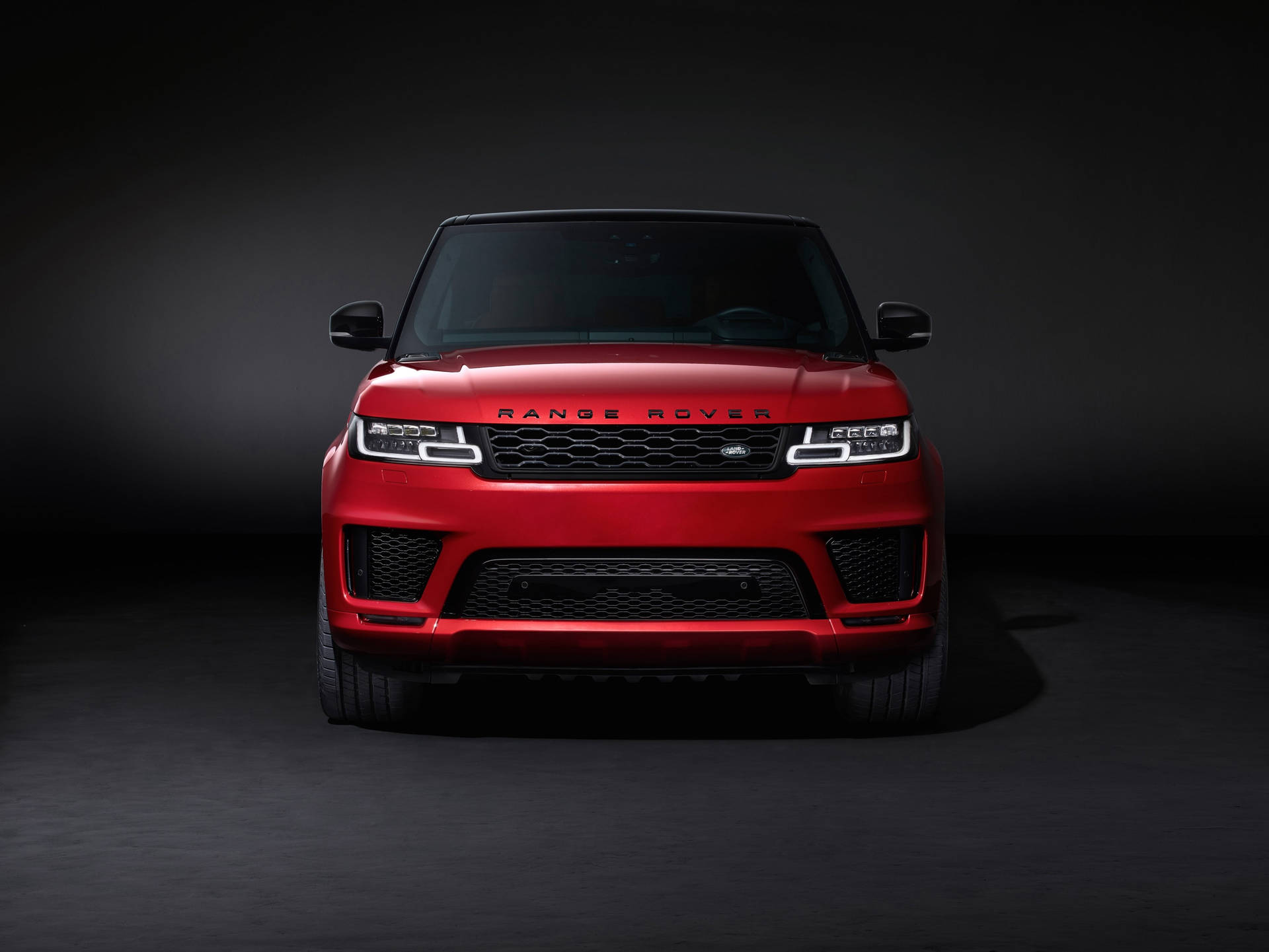 紅色 Range Rover SUV 在攝影棚中，帶有戲劇性燈光。 — 4K 壁紙