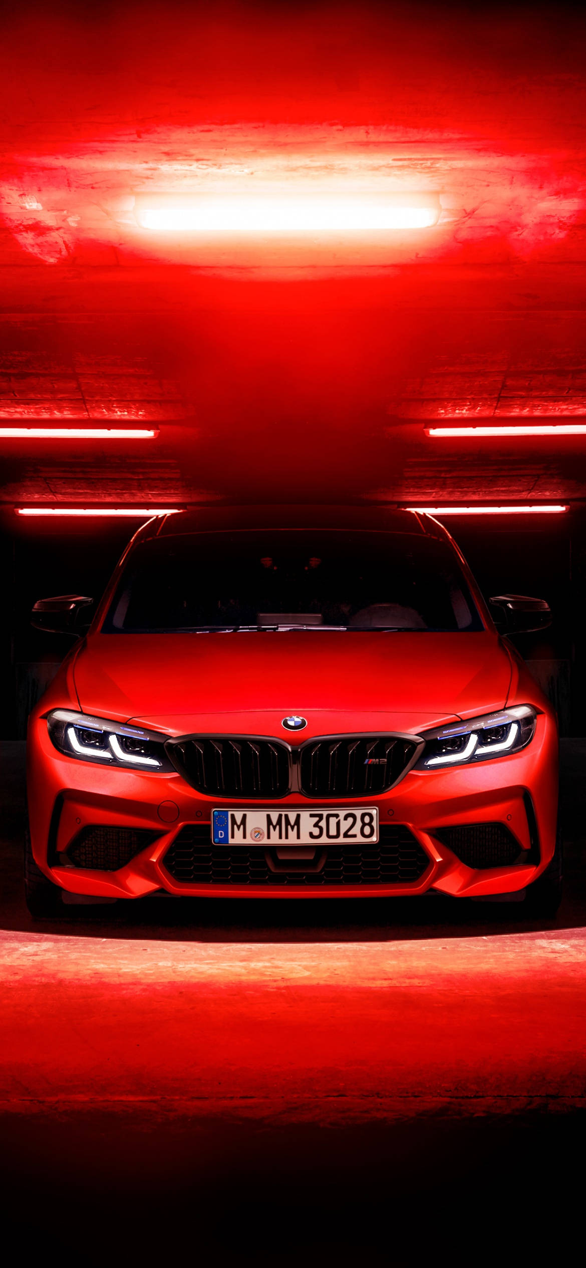 桌布 壁紙 — 一輛引人注目的紅色BMW M2跑車在隧道中被戲劇性的紅色燈光照亮，隧道內有發光的水平線條。