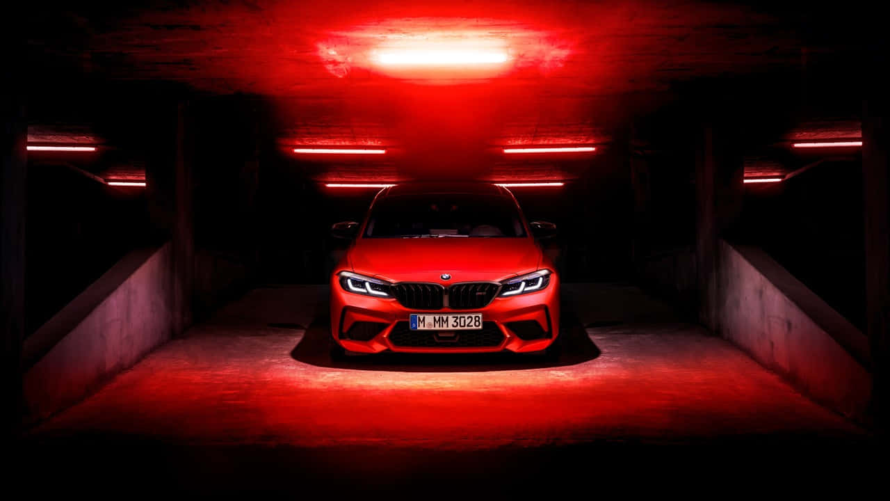 720p Bmw 桌布 壁紙 — 一輛引人注目的紅色BMW M3停放在燈光昏暗的地下停車場，沐浴在強烈的紅色環境照明中。