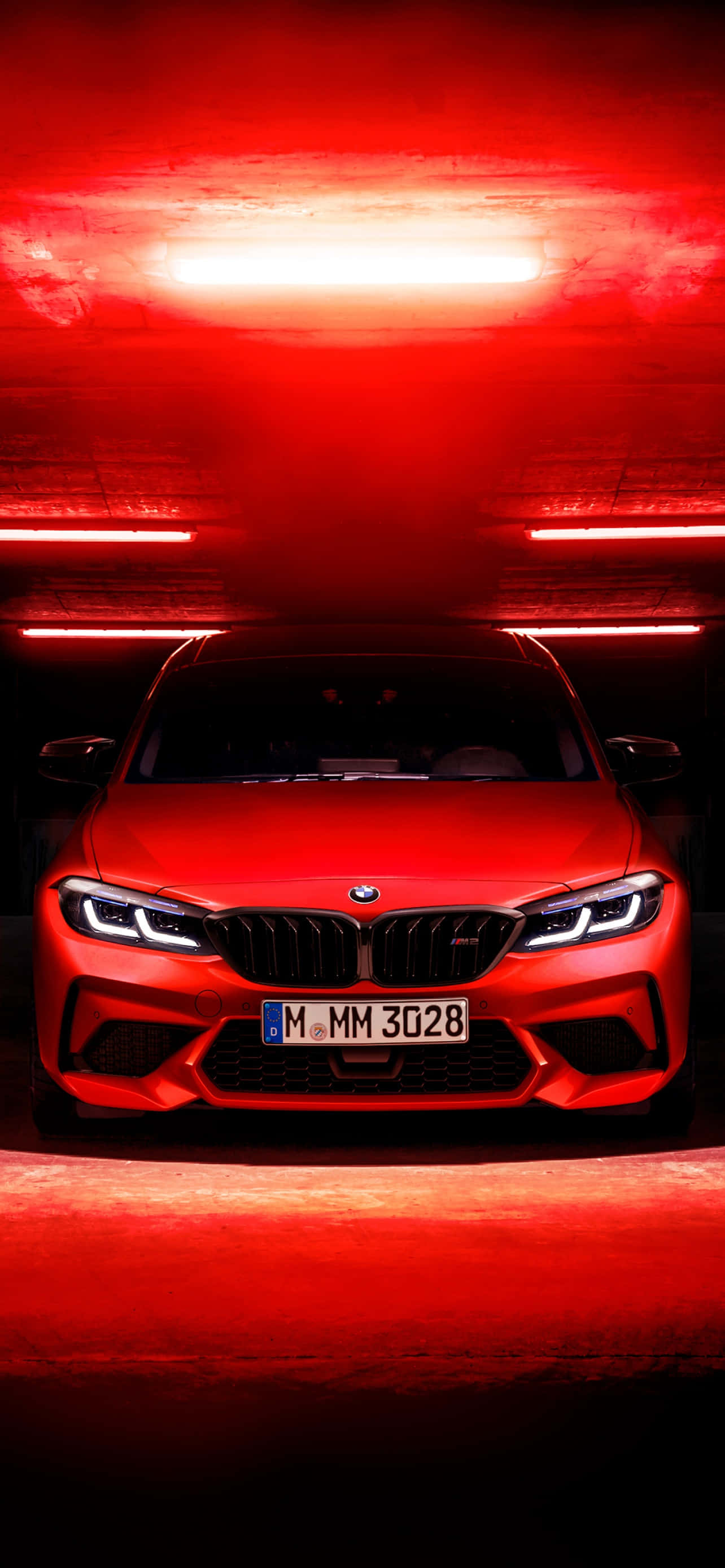 BMW 動圖 桌布 壁紙 — 一輛引人注目的紅色BMW M3跑車在黑暗隧道中被戲劇性的紅色照明和發光的水平線條照亮。