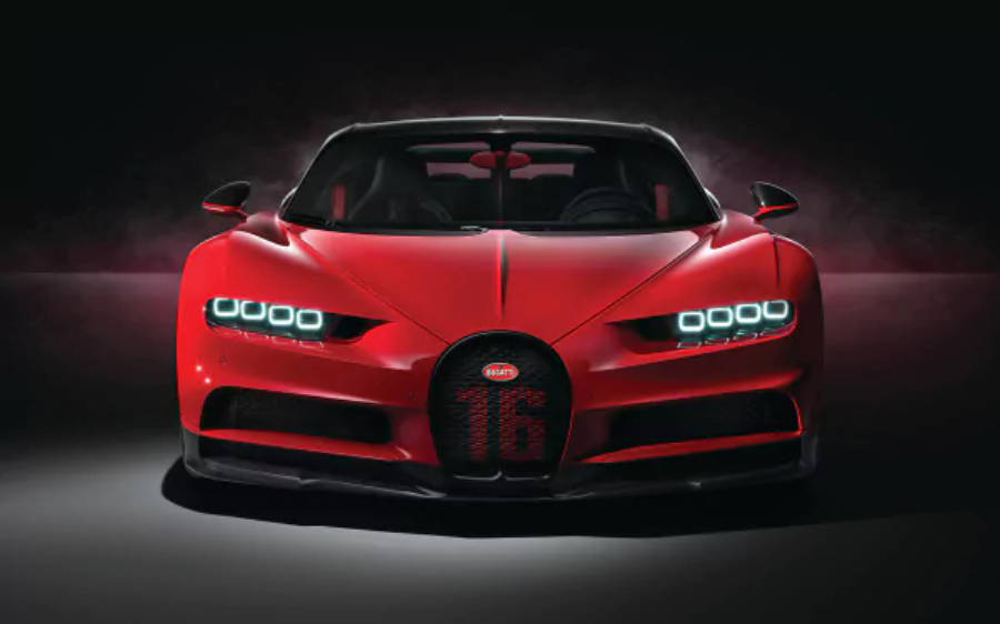 4K 桌布 壁紙 — 一輛引人注目的紅色Bugatti Chiron Super Sport 2020，帶有發光的頭燈和「16」標誌，在黑暗的攝影棚背景下戲劇性地照亮。