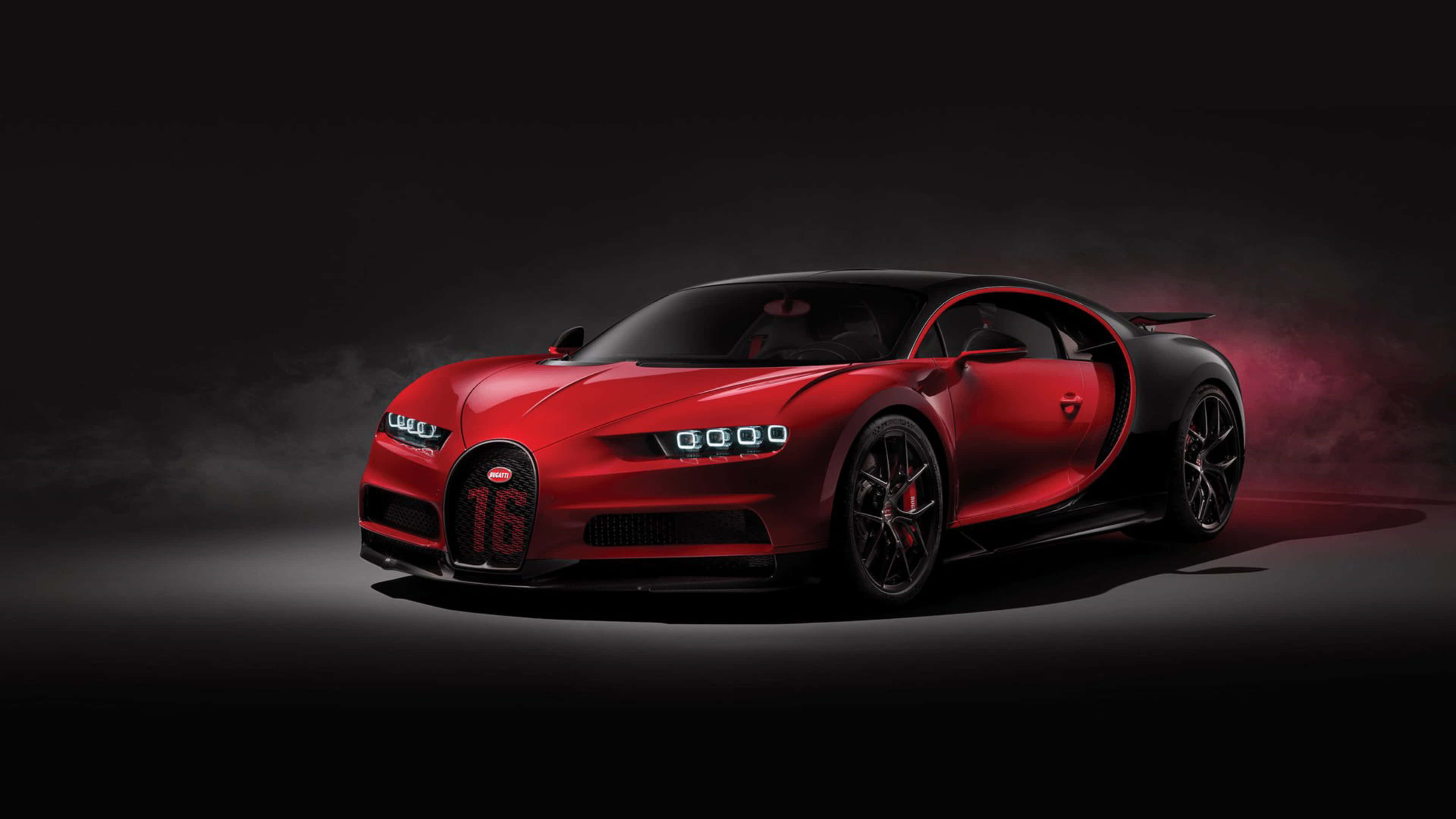 桌布 壁紙 — 一輛引人注目的紅色Bugatti Chiron Super Sport 300+，帶有黑色飾邊和發光頭燈，在黑暗煙霧背景中戲劇性地矗立。