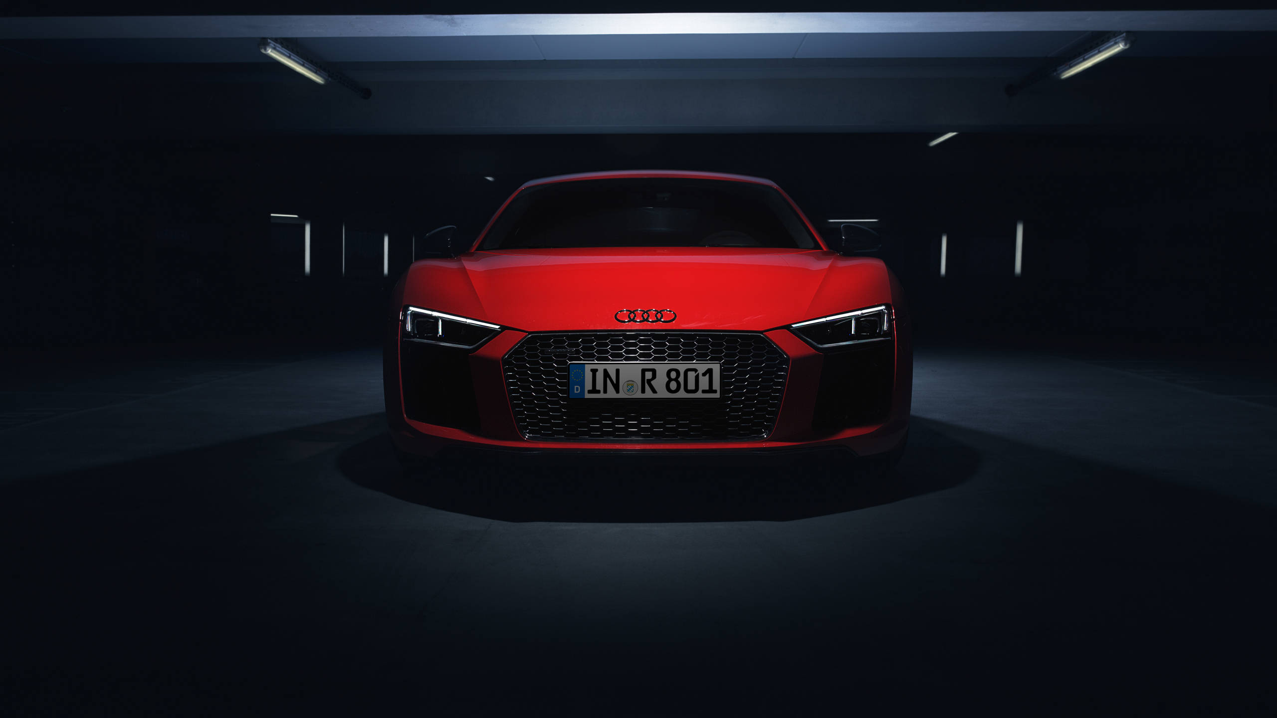cars 桌布 壁紙 — 一輛引人注目的紅色奧迪R8跑車停放在光線昏暗的地下車庫中央，頭頂燈光投射出戲劇性的陰影。