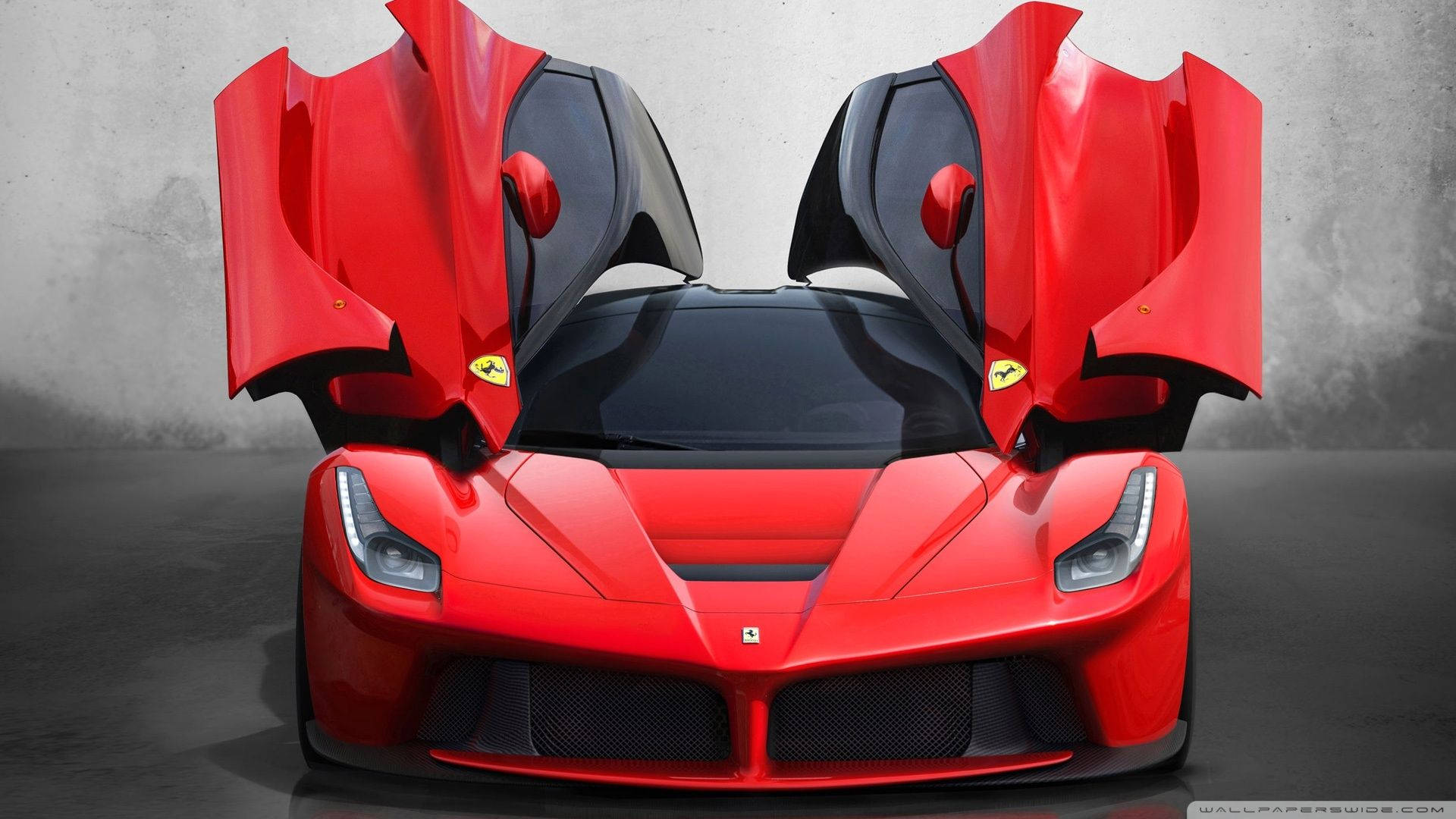 法拉利 桌布 壁紙 — 一輛引人注目的紅色法拉利LaFerrari，其標誌性的鷗翼車門敞開，在簡約的灰色混凝土背景下展示。