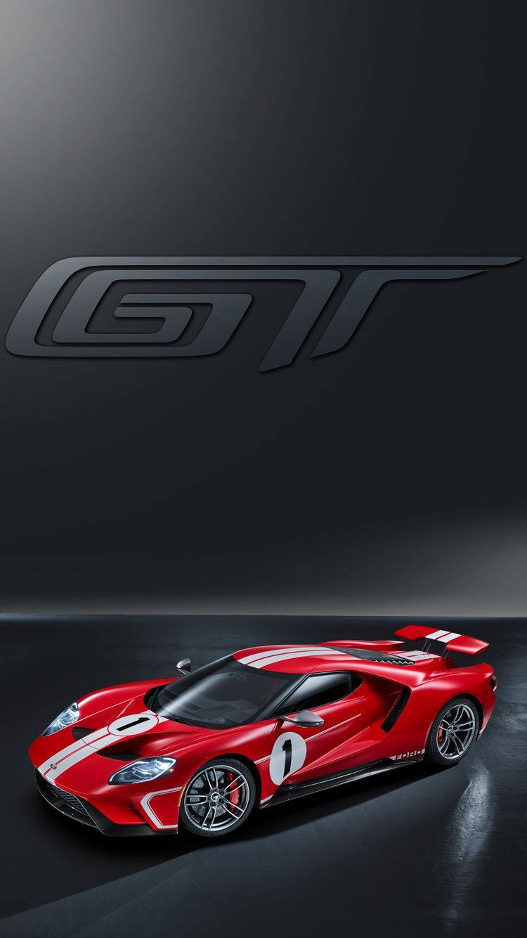 ford iPhone 桌布 壁紙 — 一輛引人注目的紅色福特GT賽車，帶有白色條紋和數字一，在攝影棚燈光下閃耀，背景為深灰色，帶有大型GT標誌。