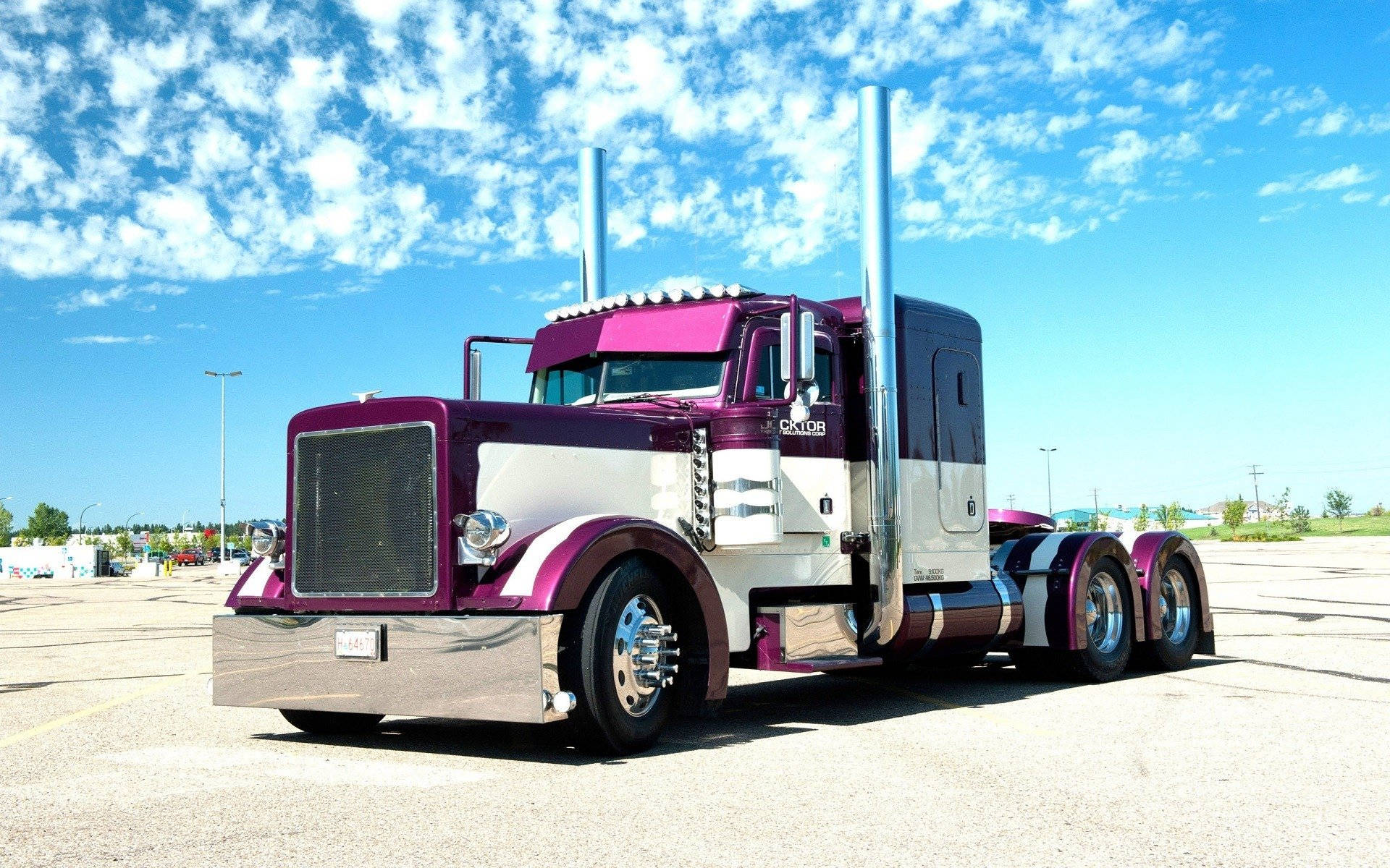 Peterbilt 桌布 壁紙 — 一輛引人注目的紫色和白色半掛卡車，帶有鍍鉻裝飾，停在藍天白雲下。