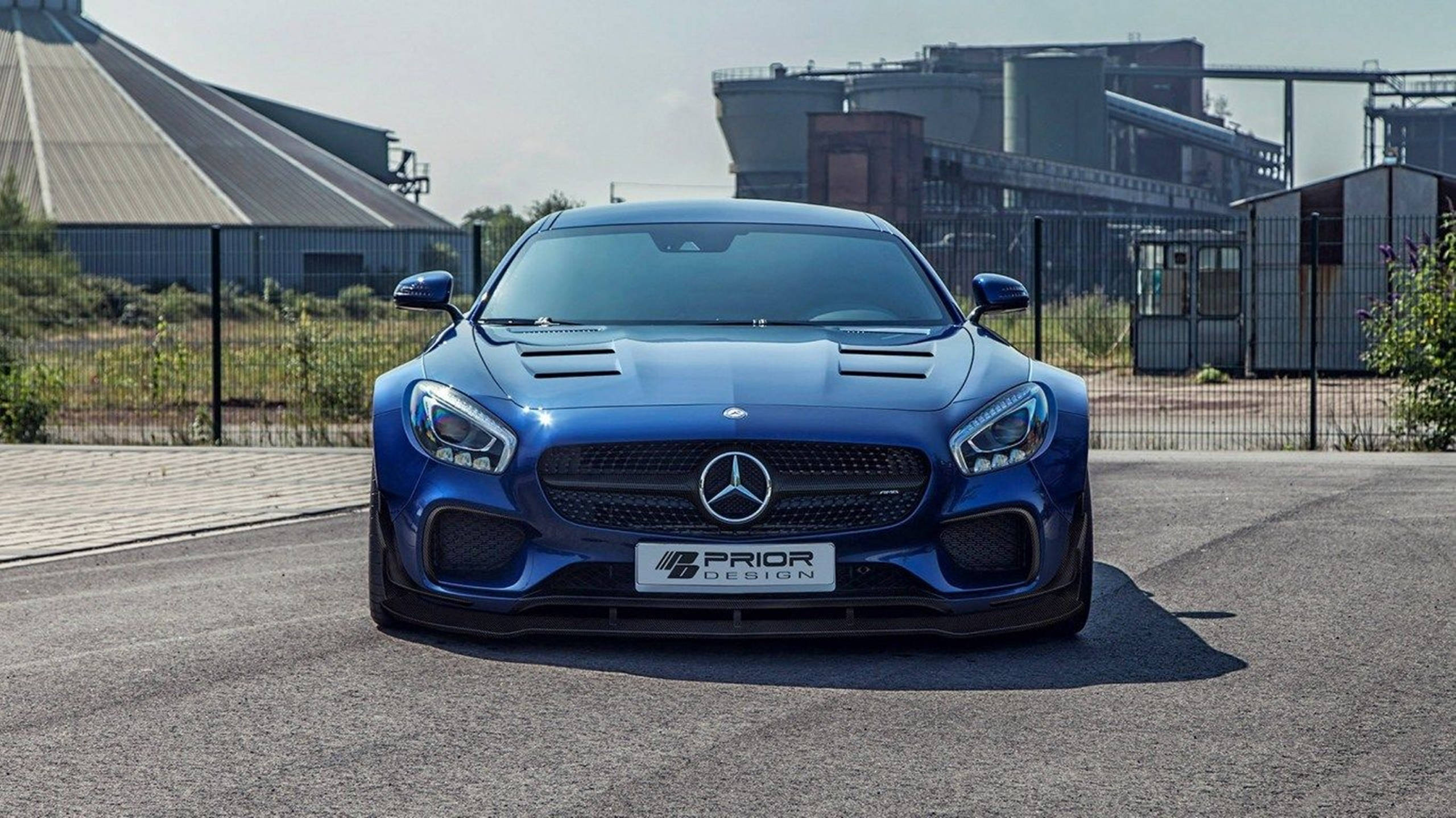 高清 桌布 壁紙 — 一輛引人注目的藍色Mercedes-AMG GT S，帶有Prior Design改裝，停在工業綜合體前的瀝青路面上。