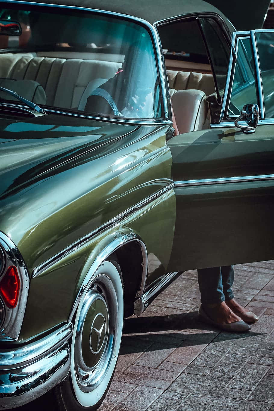 Classic Mercedes 桌布 壁紙 — 一輛復古橄欖綠色的梅賽德斯-奔馳敞篷車，帶有鍍鉻裝飾和白色輪胎，停在磚砌路面上。