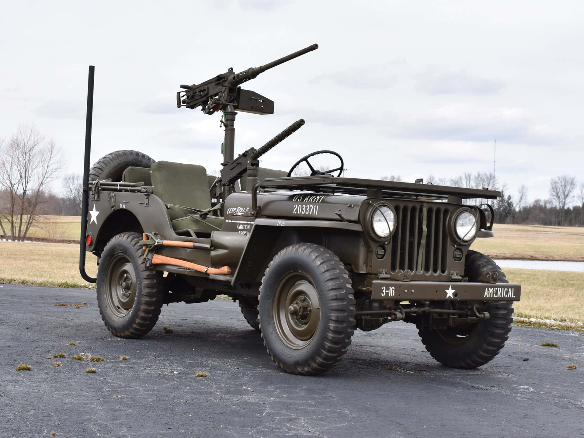 Jeep Willys 桌布 壁紙 — 一輛復古橄欖綠軍用吉普車，裝有機槍，停在柏油路面上，背景是陰天。