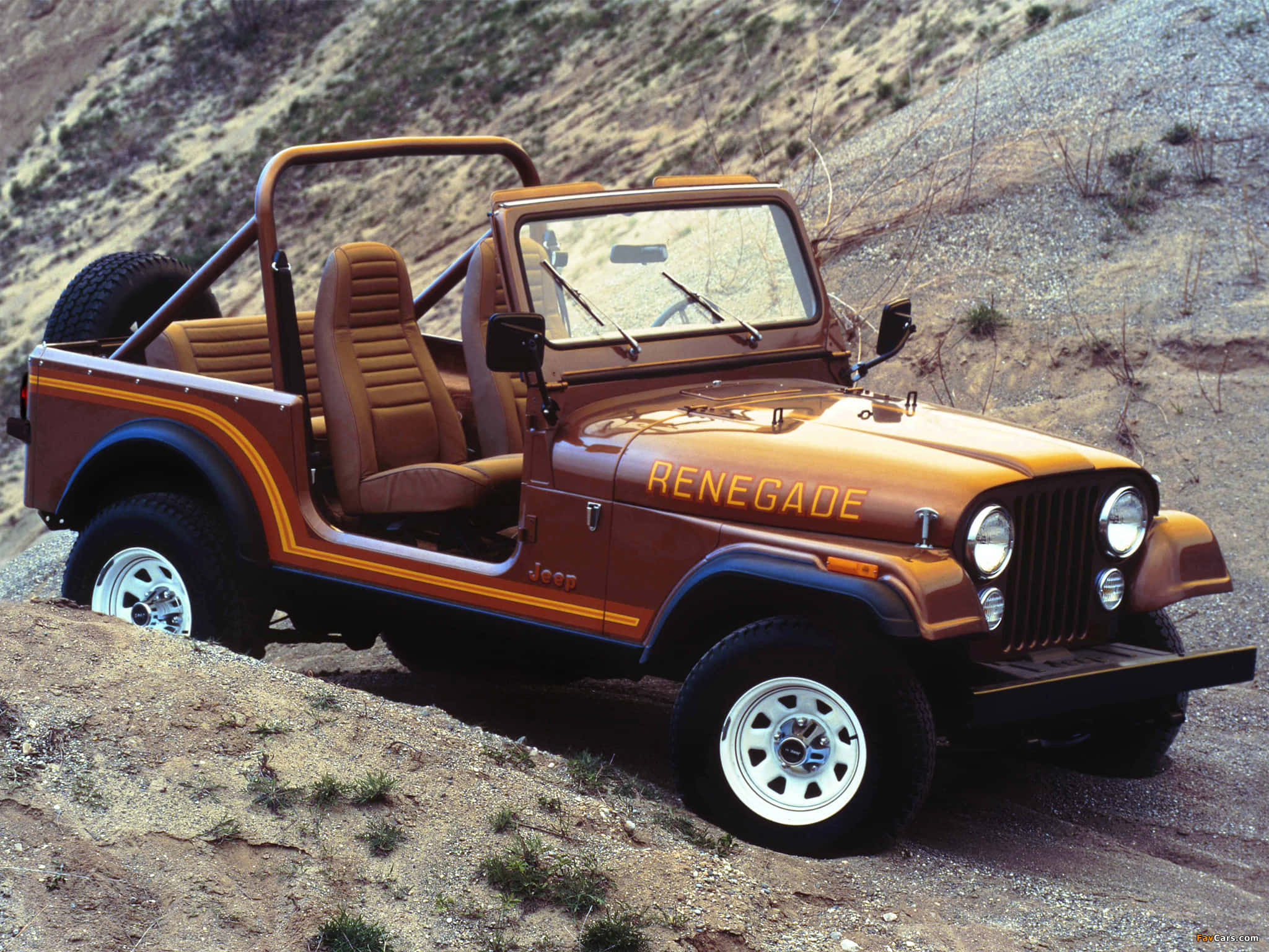 Jeep Cj 桌布 壁紙 — 一輛復古橙色Jeep Renegade，配米色內裝，停在陽光明媚的岩石沙漠斜坡上。