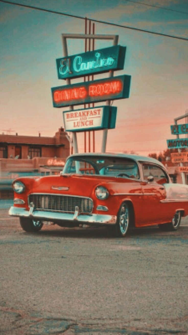 Retro 桌布 壁紙 — 一輛復古紅色汽車在日落時分停泊在發光的El Camino餐廳霓虹燈牌下。