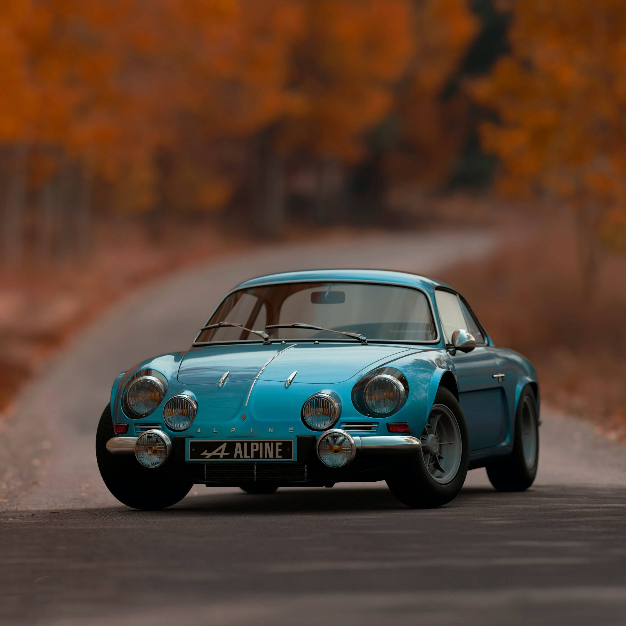 Auto Racing 桌布 壁紙 — 一輛復古綠松色Alpine跑車行駛在蜿蜒的秋季道路上，兩旁是火紅的橙色樹木。