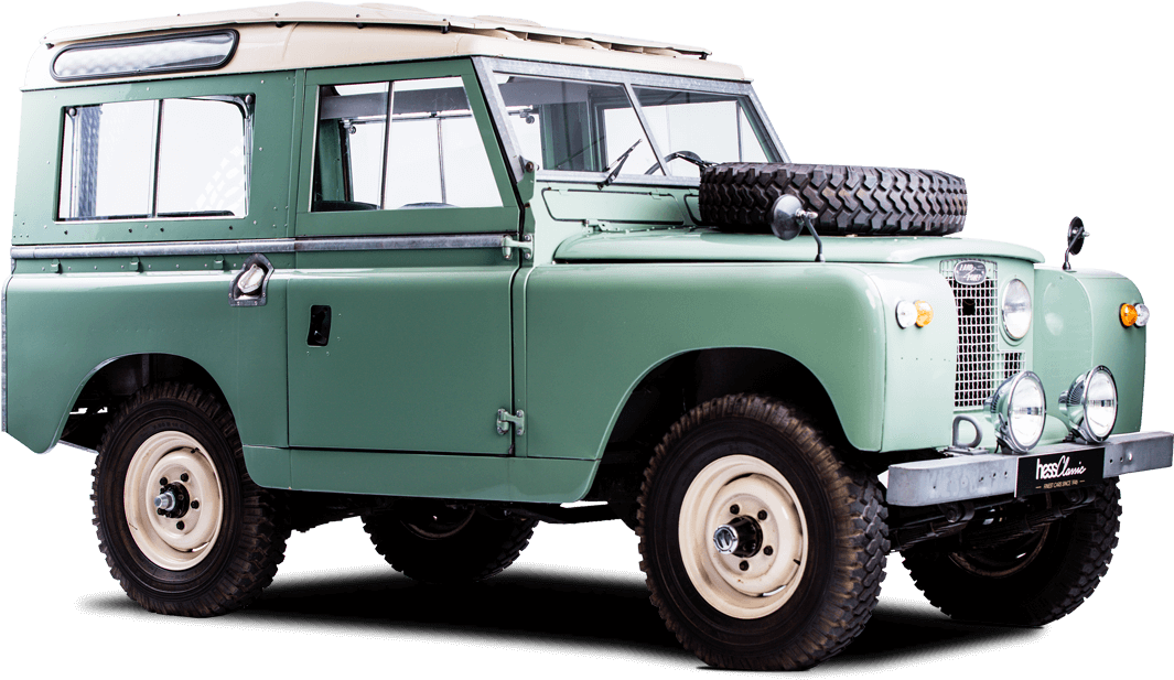荒原路華 桌布 壁紙 — 一輛復古綠色 Land Rover Series IIA，帶有奶油色點綴和安裝在引擎蓋上的備用輪胎，孤立在黑色背景前。