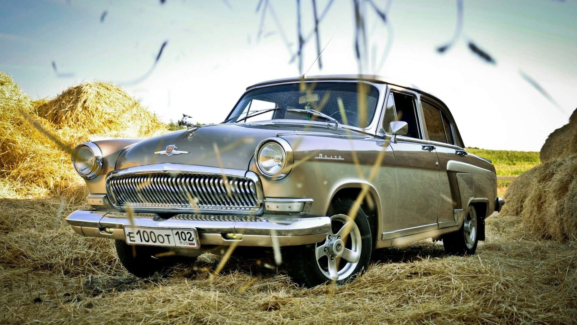 Hindustan Motors 桌布 壁紙 — 一輛復古銀色汽車停放在金黃色乾草捆之間，前景有乾草。