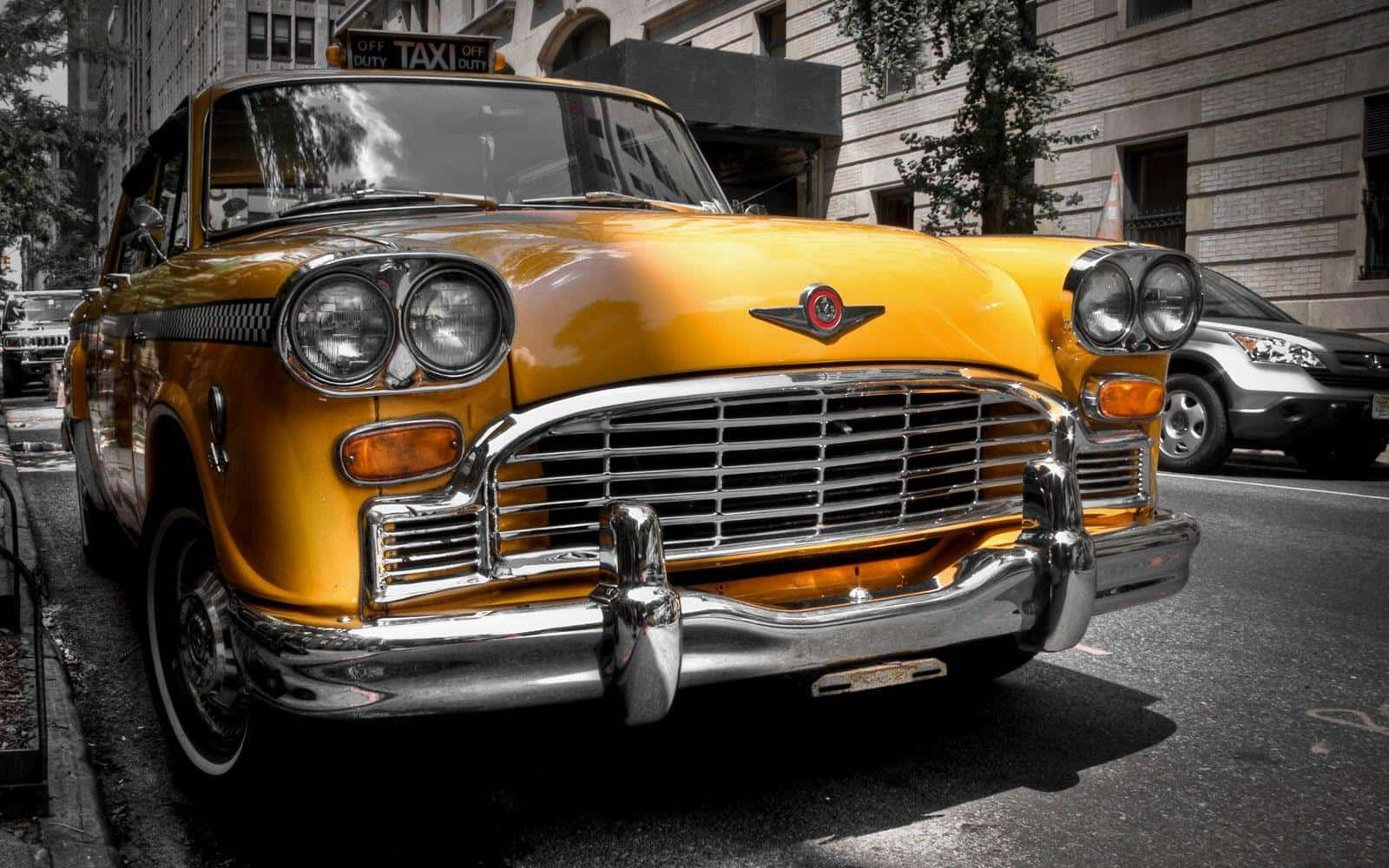 Vintage Car 桌布 壁紙 — 一輛復古黃色計程車帶有鍍鉻裝飾，在明亮的日光下停放在城市街道上。