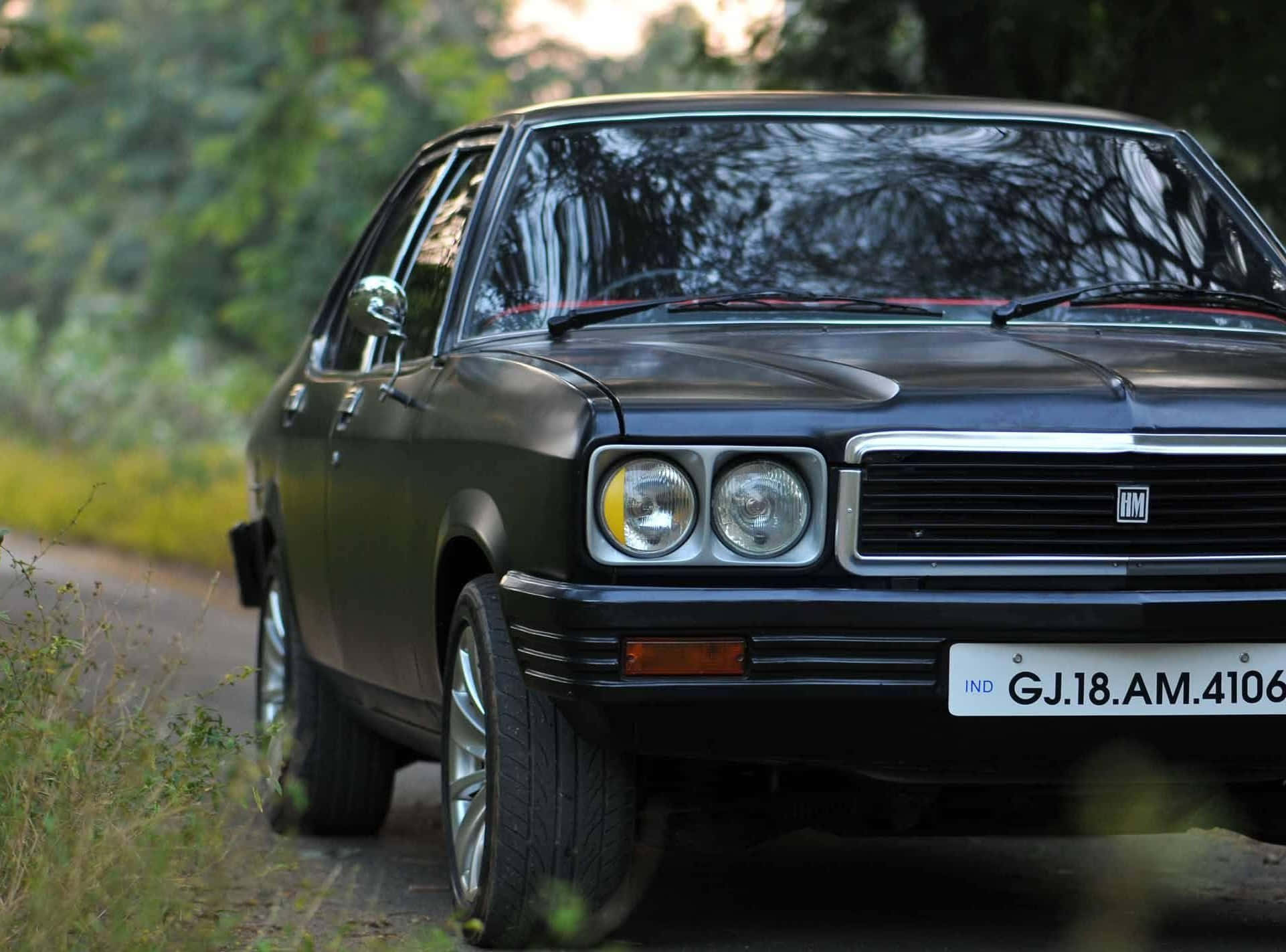 Hindustan Motors 桌布 壁紙 — 一輛復古黑色Maruti 800停泊在森林小路上，柔和的金色光線穿過樹木灑落。