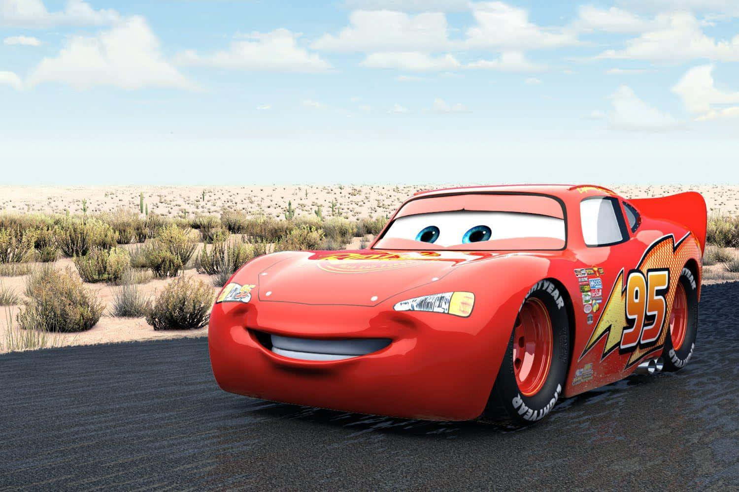 Lightning Mcqueen 桌布 壁紙 — 一輛快樂的紅色動畫賽車，編號95，在藍天白雲下的沙漠公路上微笑。