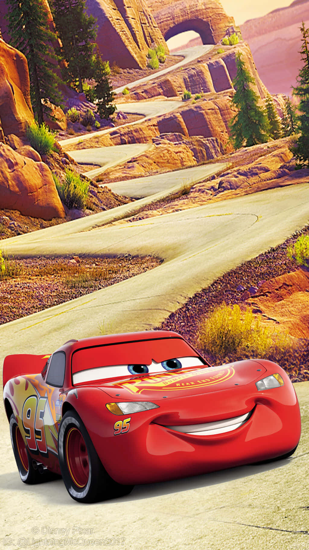 Lightning Mcqueen 桌布 壁紙 — 一輛快樂的紅色賽車，號碼95，在蜿蜒的沙漠道路上穿過岩石峽谷地形微笑。