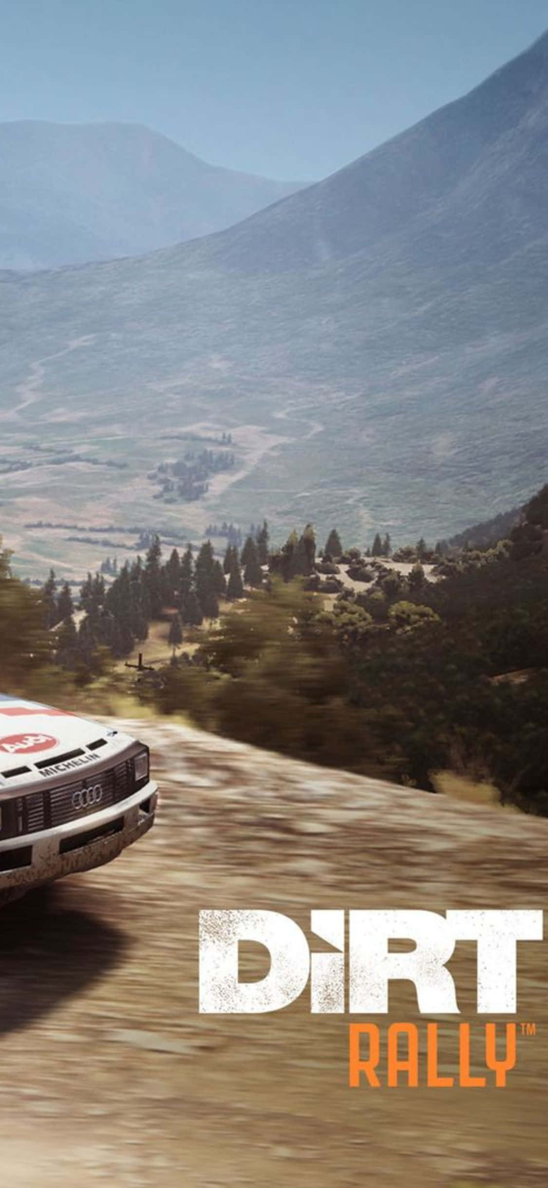 iPhone Xs Dirt Rally 桌布 壁紙 — 一輛拉力賽車在塵土飛揚的山路上疾駛，兩旁是松樹林和遠方的山峰，天空湛藍清澈。