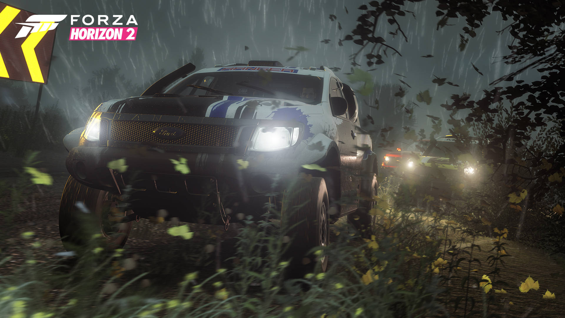 Horizon 桌布 壁紙 — 一輛拉力賽車在雨水浸濕的森林賽道上疾馳，車頭燈劃破落下的雨水和發光的黃色花朵。