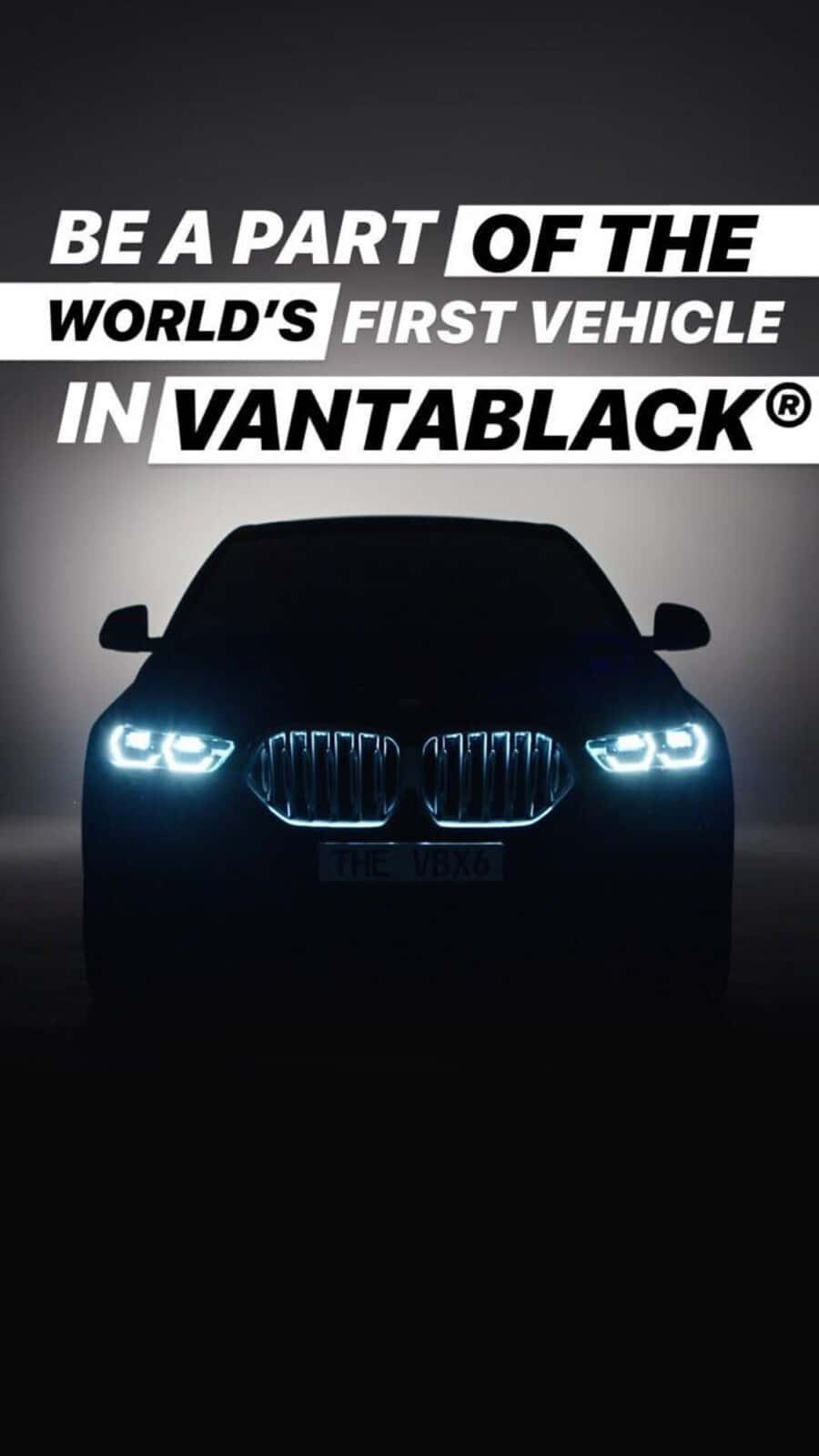 Vantablack 桌布 壁紙 — 一輛採用Vantablack塗裝的BMW汽車，在黑暗的攝影棚背景下，明亮的車頭燈閃耀，並帶有粗體文字疊加。