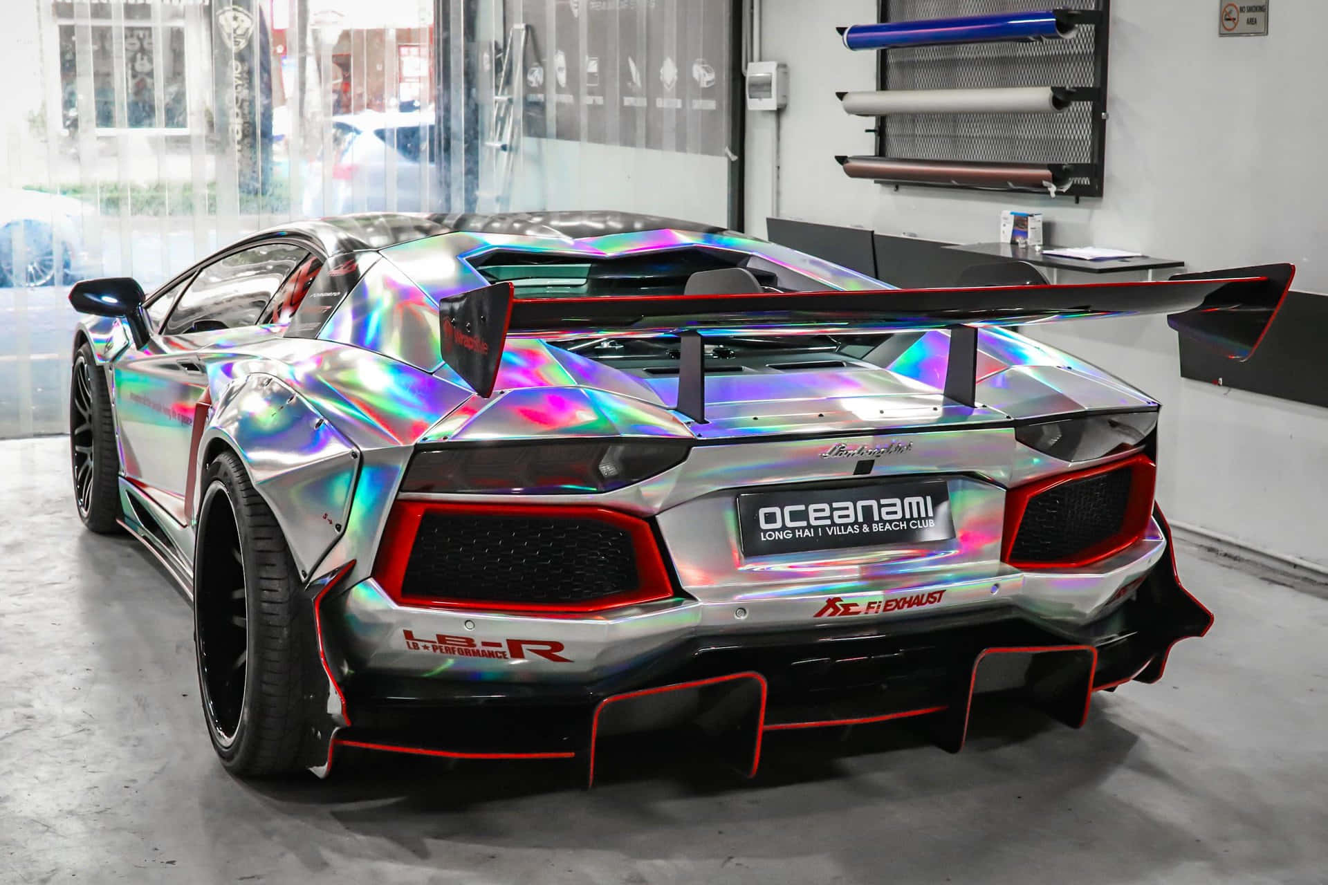 跑車 桌布 壁紙 — 一輛採用虹彩鍍鉻漆面的藍寶堅尼 Aventador 在車庫燈光下閃閃發光，展現大膽的紅色點綴和定製貼花。