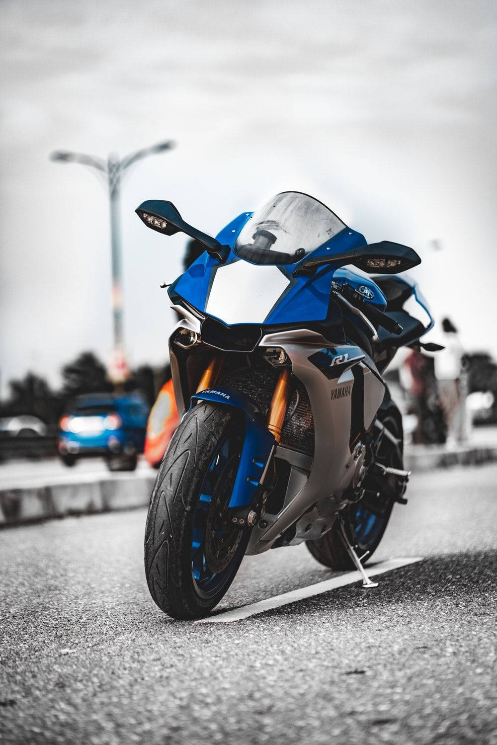 腳踏車 桌布 壁紙 — 一輛搶眼的藍色Yamaha R1運動機車停在柏油路上，背景飽和度降低。