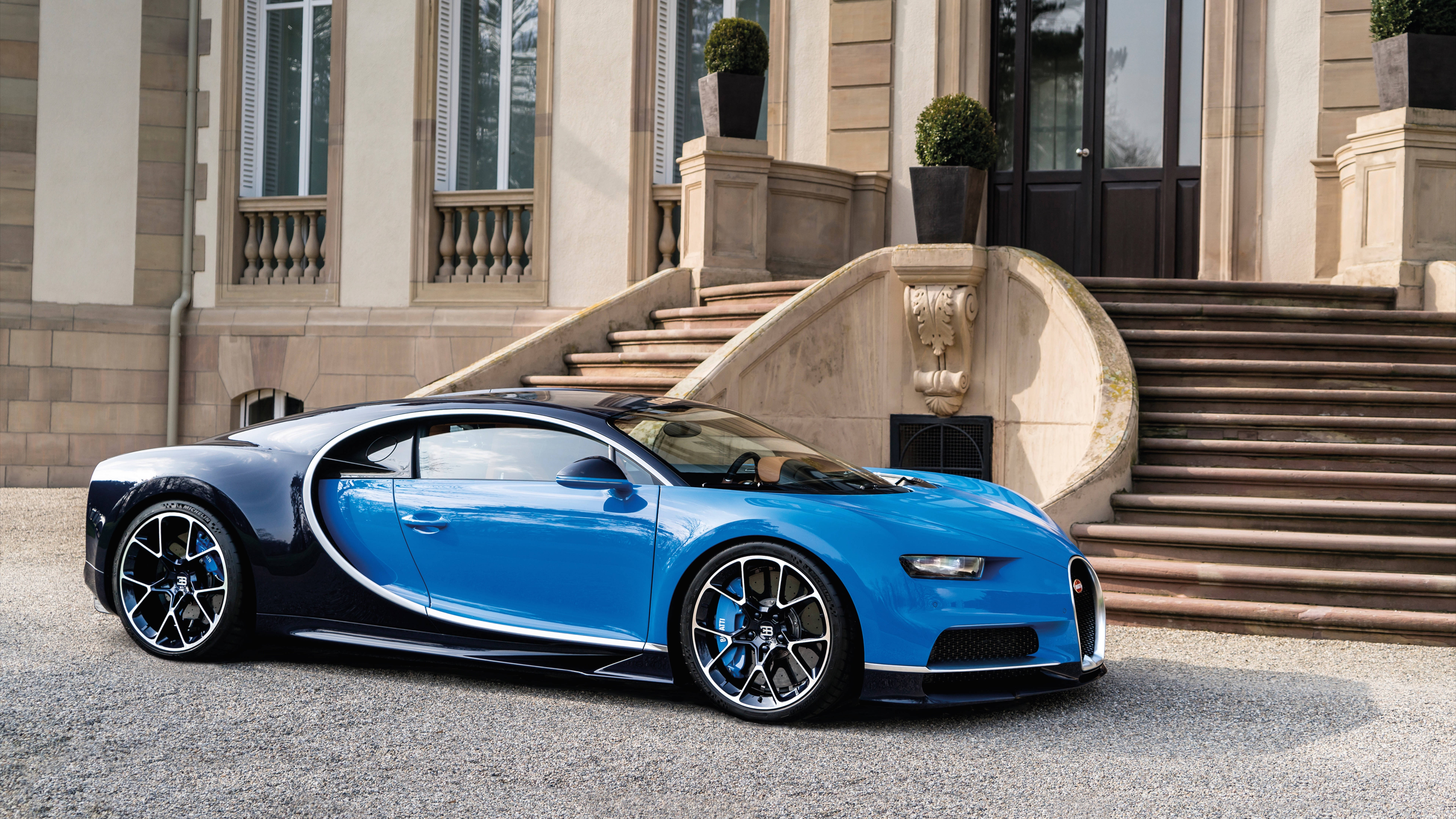 Cool Bugatti 桌布 壁紙 — 一輛搶眼的藍黑 Bugatti Veyron 停在碎石路上，前方是宏偉的石砌豪宅，帶有寬闊的階梯。