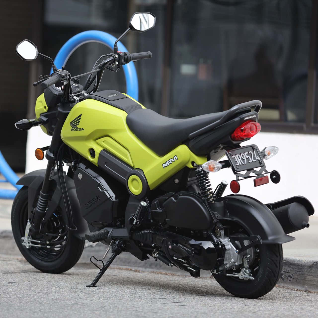 scooter 桌布 壁紙 — 一輛明亮的萊姆綠色本田 Navi 機車停放在人行道上，帶有黑色飾邊和鍍鉻細節。