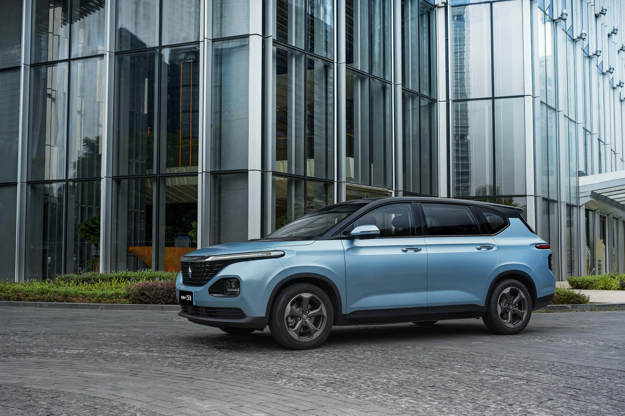 Baojun 桌布 壁紙 — 一輛時尚淺藍色SUV停放在現代玻璃建築前的鵝卵石街道上。