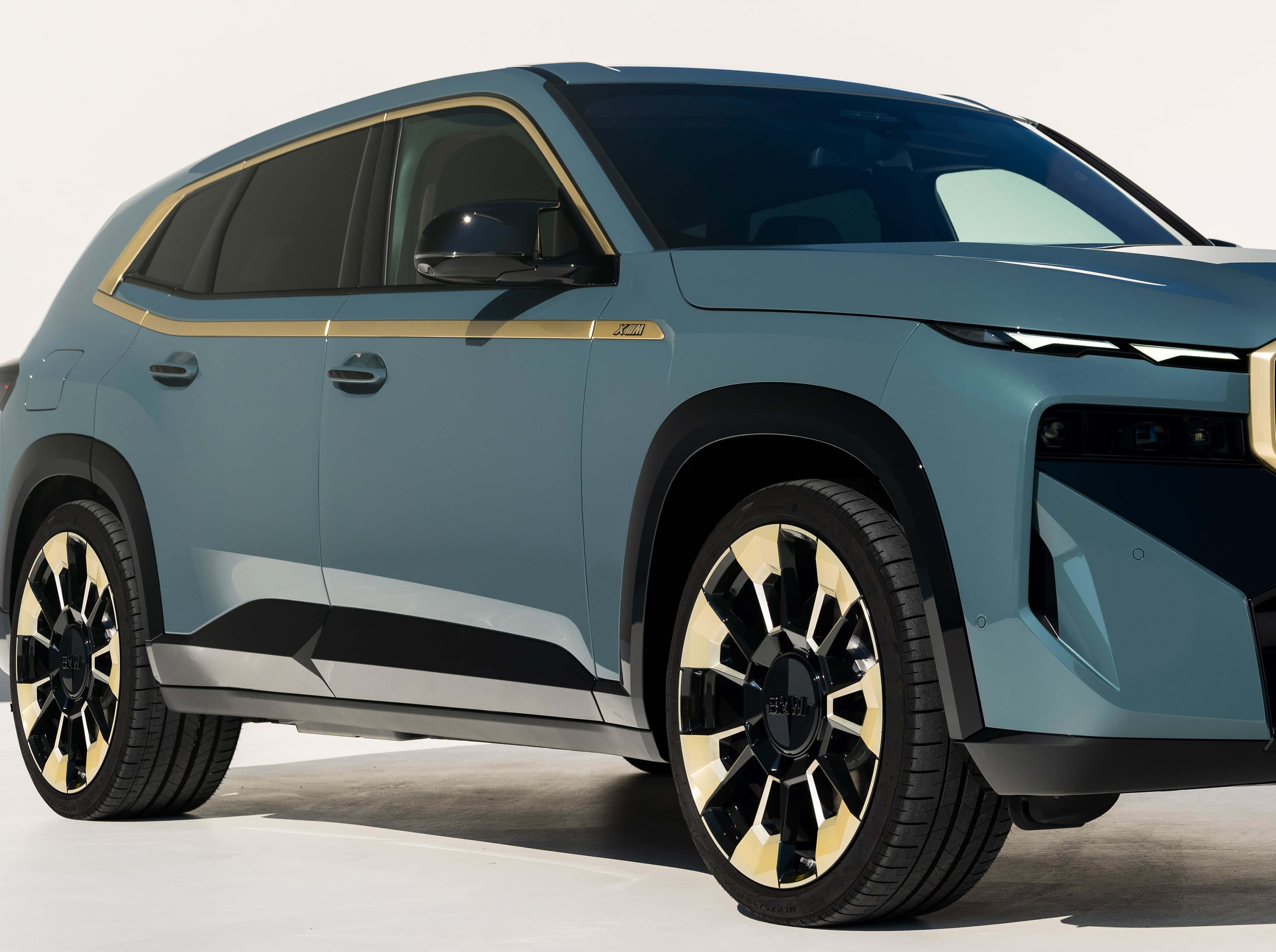 跑車 桌布 壁紙 — 一輛時尚現代藍色SUV，配備金色飾邊和黑色輪圈，矗立在簡約的攝影棚環境中。