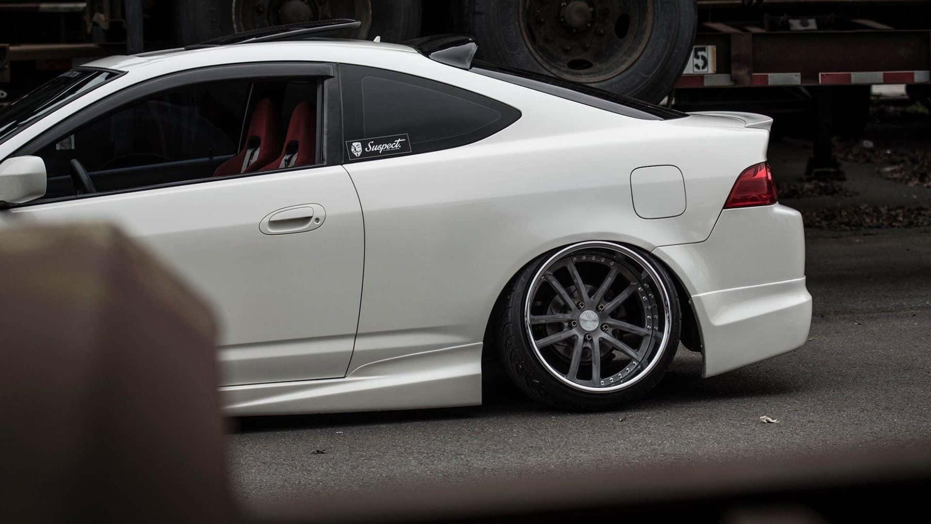 Rsx Type-s 桌布 壁紙 — 一輛時尚白色改裝轎跑車，配備訂製輪圈，停放在柏油路上，旁邊有卡車拖車。