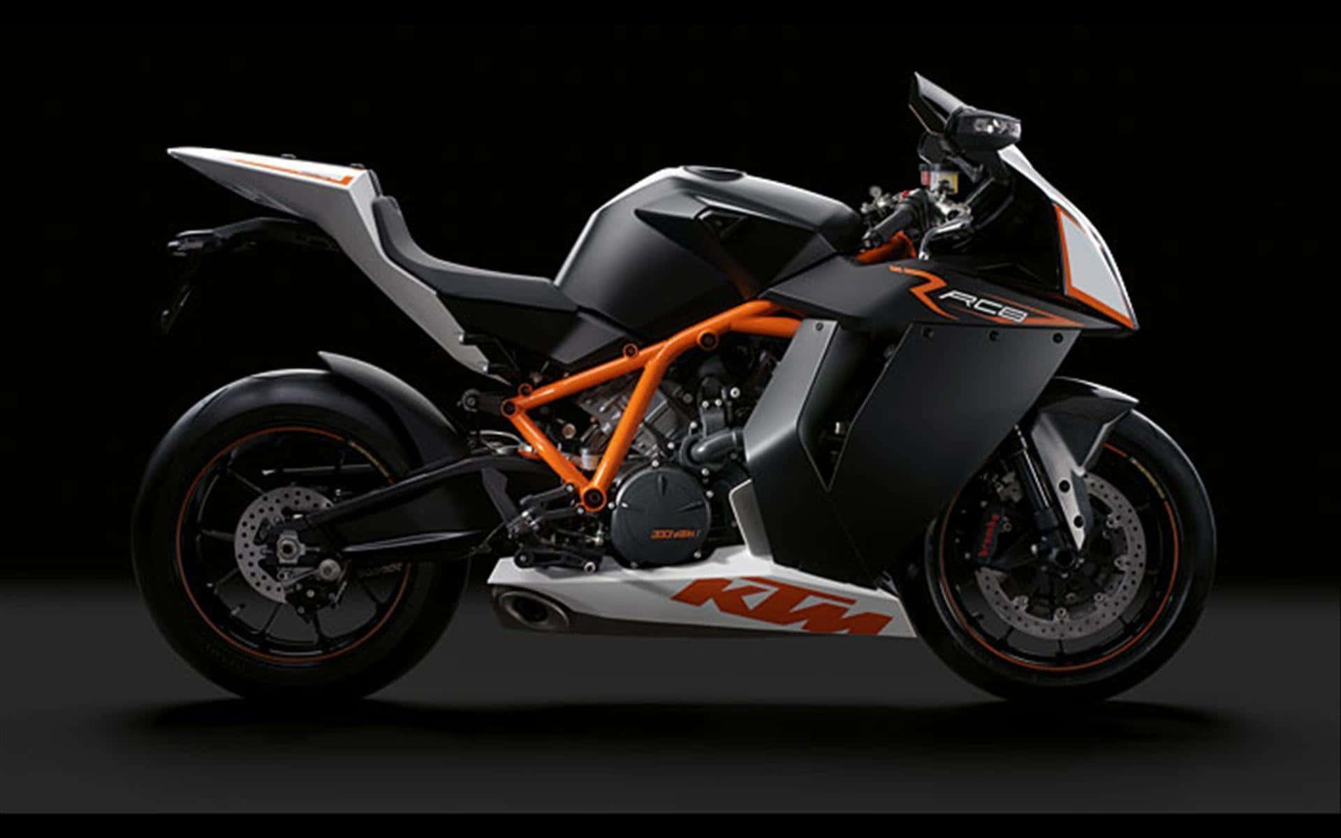 機車 桌布 壁紙 — 一輛時尚的KTM RC8運動機車，帶有橙色和黑色點綴，在戲劇性的攝影棚燈光下，以深色背景為襯托。