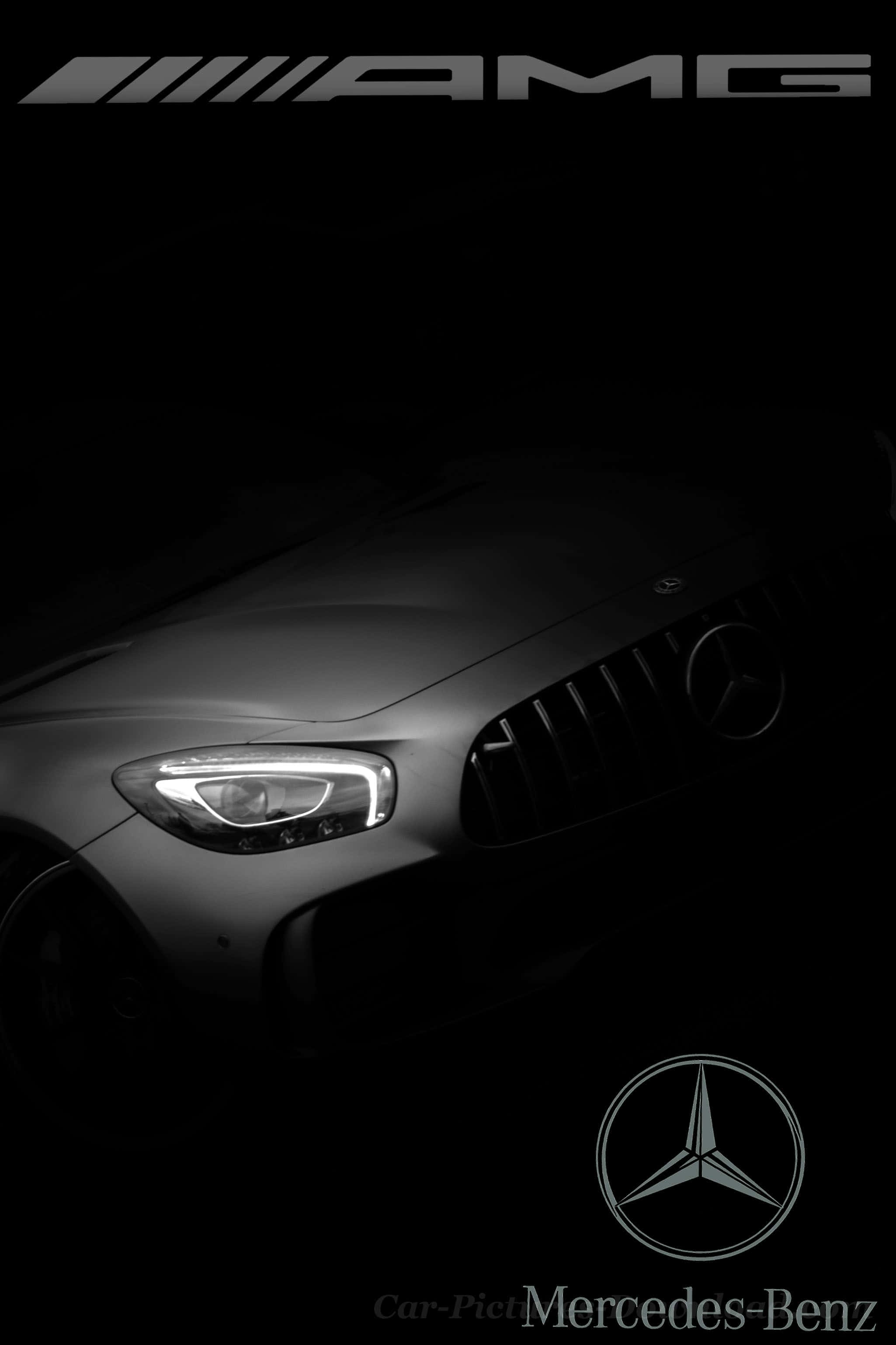 手機 桌布 壁紙 — 一輛時尚的Mercedes-AMG汽車前臉在聚光燈下閃耀，背景漆黑一片。