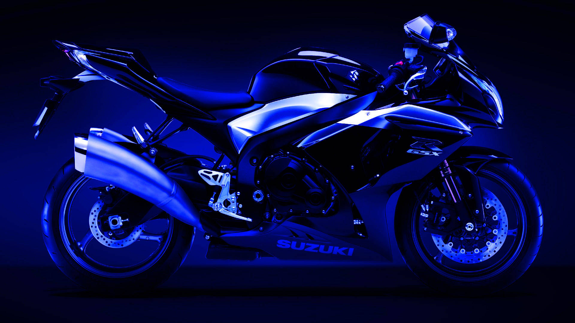  壁紙 — 一輛時尚的Suzuki運動機車在深色背景下，在強烈的藍色攝影棚燈光下閃閃發光。