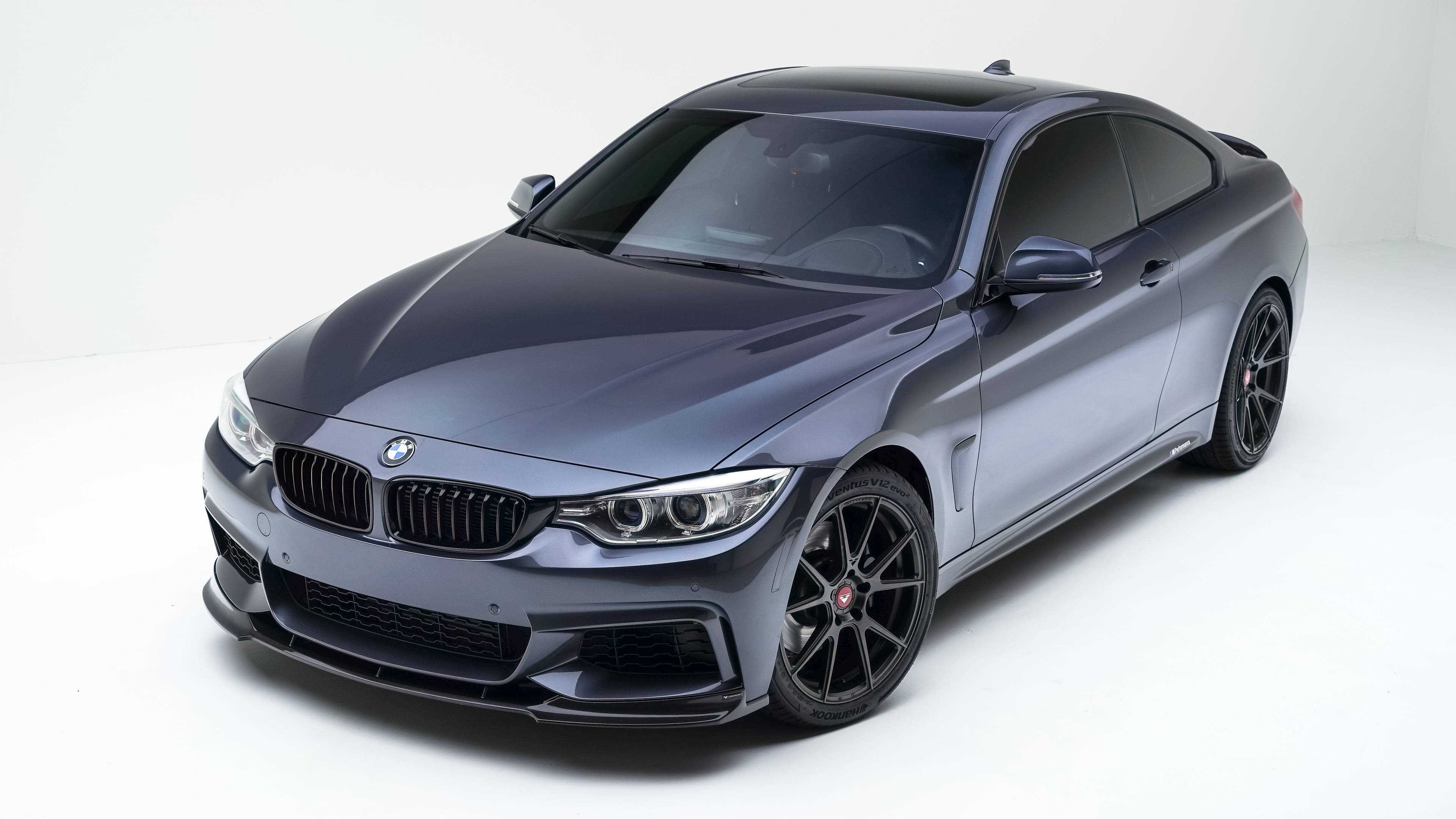 桌布 壁紙 — 一輛時尚的啞光灰色BMW雙門轎跑車，帶有黑色飾件和運動型輪圈，擺放在乾淨的白色工作室背景前。