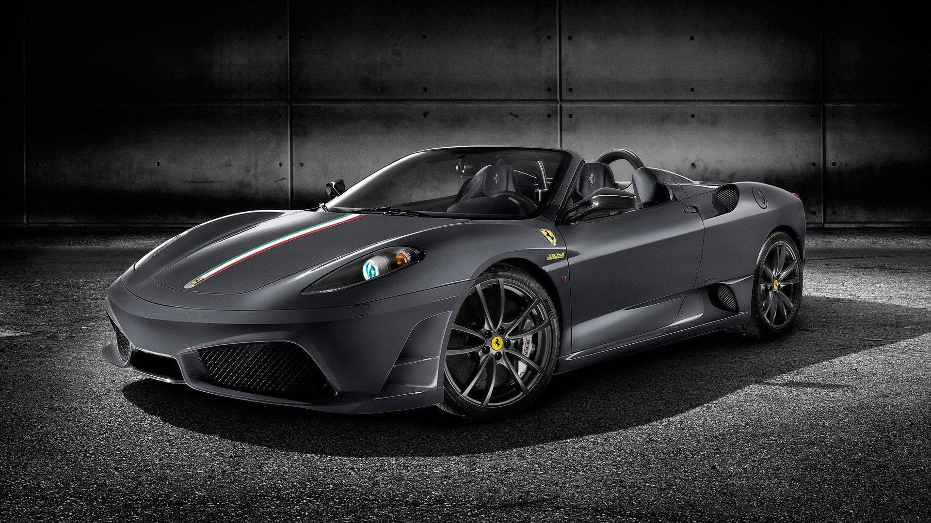 1920x1080 Ferrari 桌布 壁紙 — 一輛時尚的啞光灰色法拉利Spider，帶有黃色點綴，在戲劇性的聚光燈下，在深色混凝土牆前閃閃發光。
