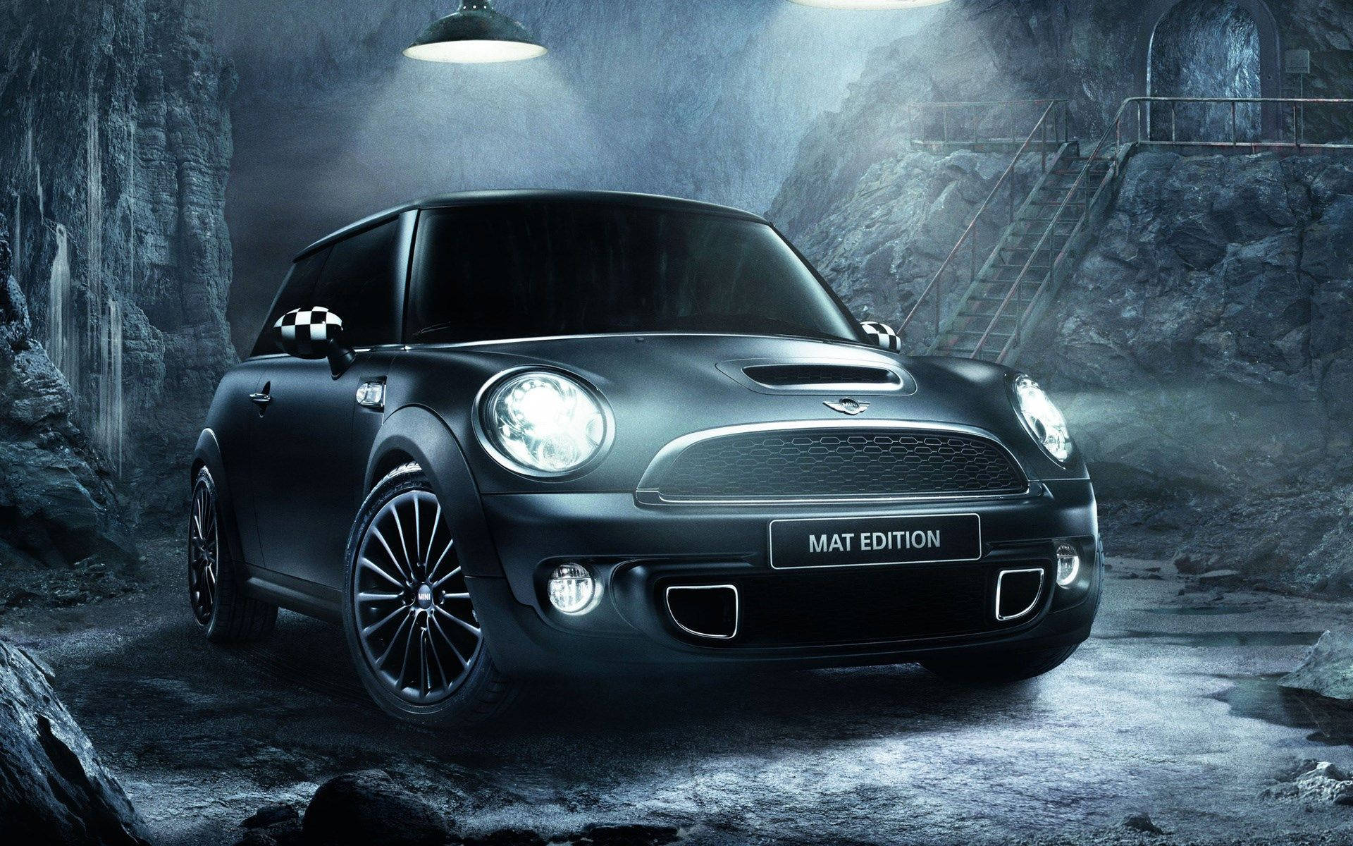 Mini Cooper 桌布 壁紙 — 一輛時尚的啞光黑色MINI Cooper Mat Edition在霧氣瀰漫、岩石遍佈的地下洞穴中，在強烈的聚光燈下閃閃發光。