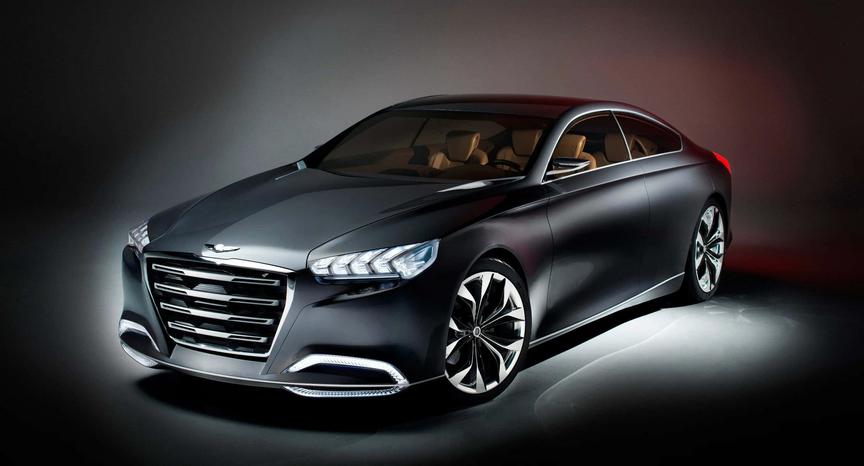 Genesis 桌布 壁紙 — 一輛時尚的啞光黑色豪華轎車，帶有發光頭燈和鍍鉻飾邊，在黑暗的攝影棚背景下戲劇性地照亮。