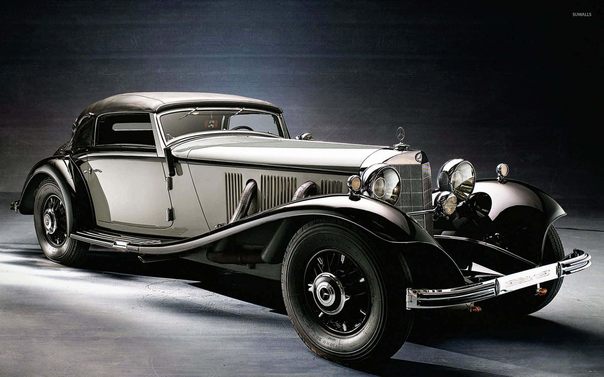 Classic Mercedes 桌布 壁紙 — 一輛時尚的復古梅賽德斯-奔馳轎跑車在戲劇性的工作室燈光下，在黑暗背景下閃閃發光。