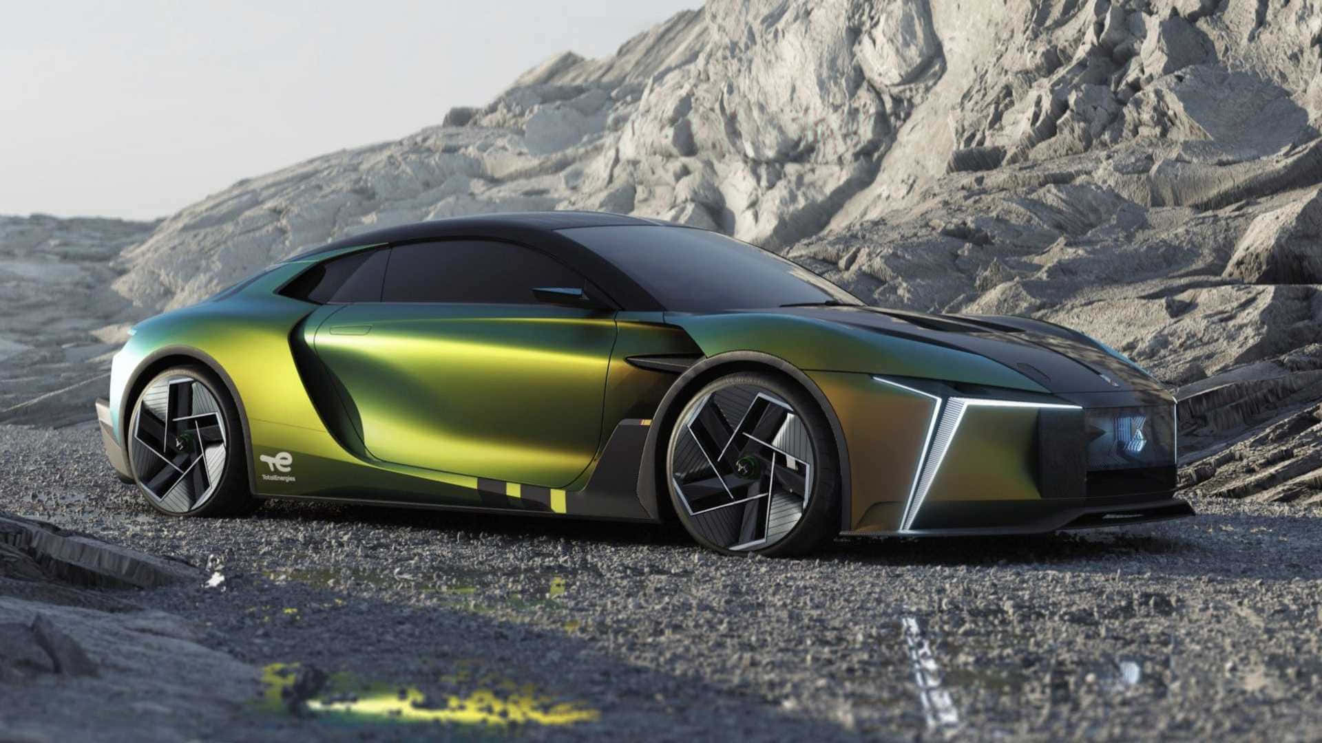 Ds Automobiles 桌布 壁紙 — 一輛時尚的未來主義綠色跑車，帶有黑色裝飾，停放在岩石地形上，背景是崎嶇的山脈。