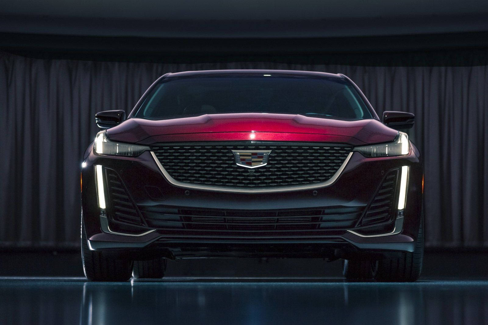 Cadillac 桌布 壁紙 — 一輛時尚的栗色凱迪拉克 CT4-V Blackwing 在攝影棚燈光下，以深色窗簾為背景閃閃發光。