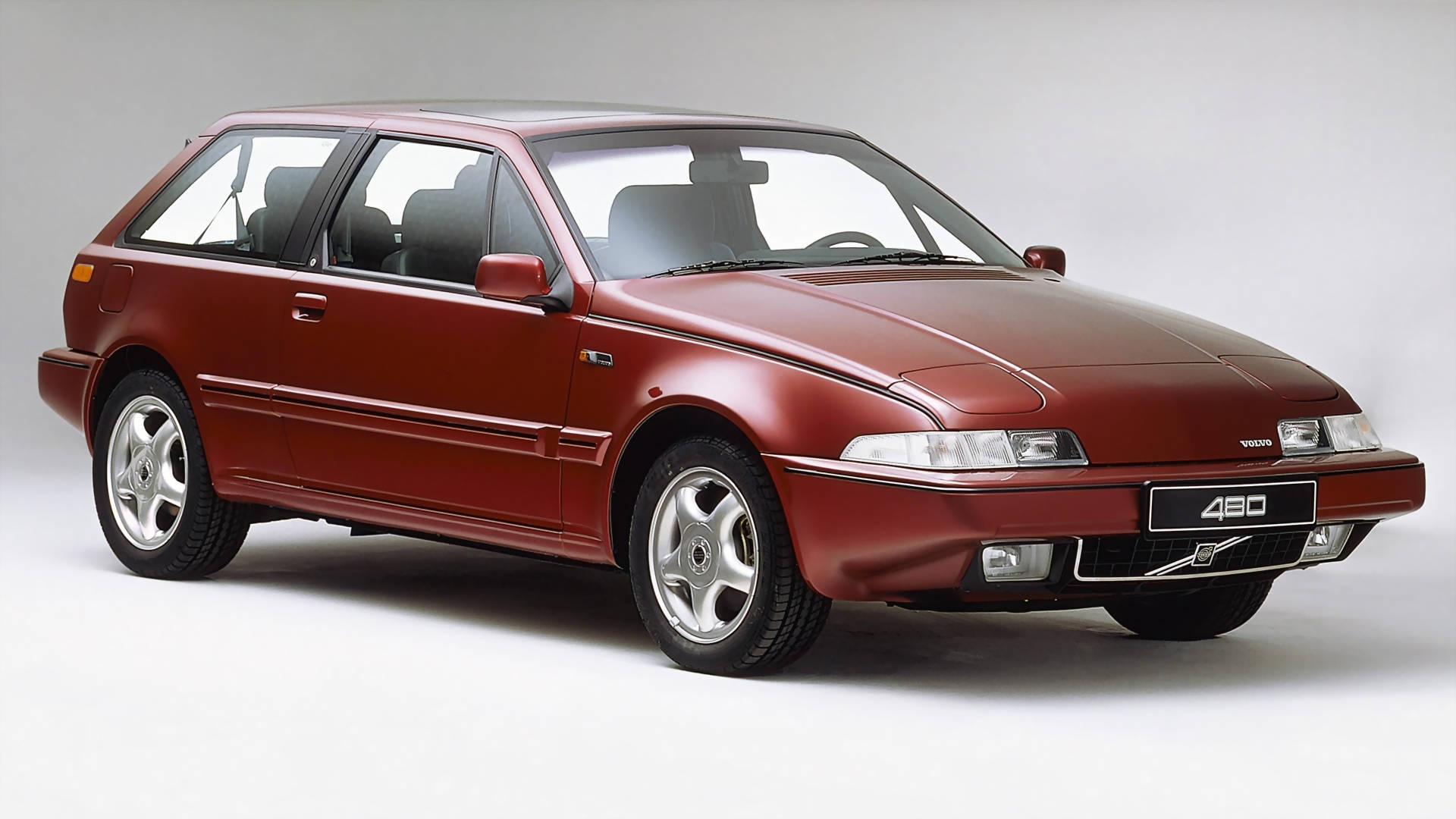 volvo iPhone 桌布 壁紙 — 一輛時尚的栗色富豪430掀背車在白色背景的攝影棚燈光下閃閃發光。