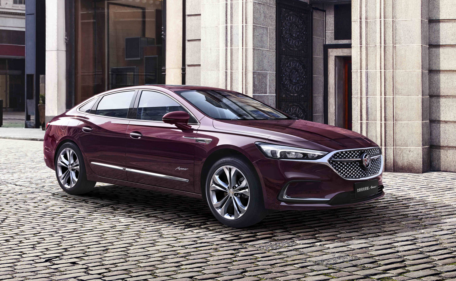 Buick 桌布 壁紙 — 一輛時尚的棗紅色豪華轎車停在鵝卵石街道上，旁邊是帶有華麗門廊的石建築。